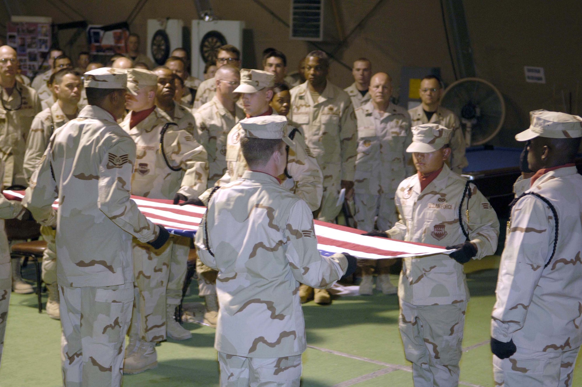 In a formal salute to Master Sgt. Brad A. Clemmons, the 332nd Air Expeditionary Wing honor guard performs a flag folding ceremony during a memorial service at Balad Air Base, Iraq, Aug. 24. Sergeant Clemmons died Aug. 21 when his vehicle struck an improvised explosive device near Taji, Iraq. (U.S. Air Force photo/Senior Airman Andrew Oquendo)