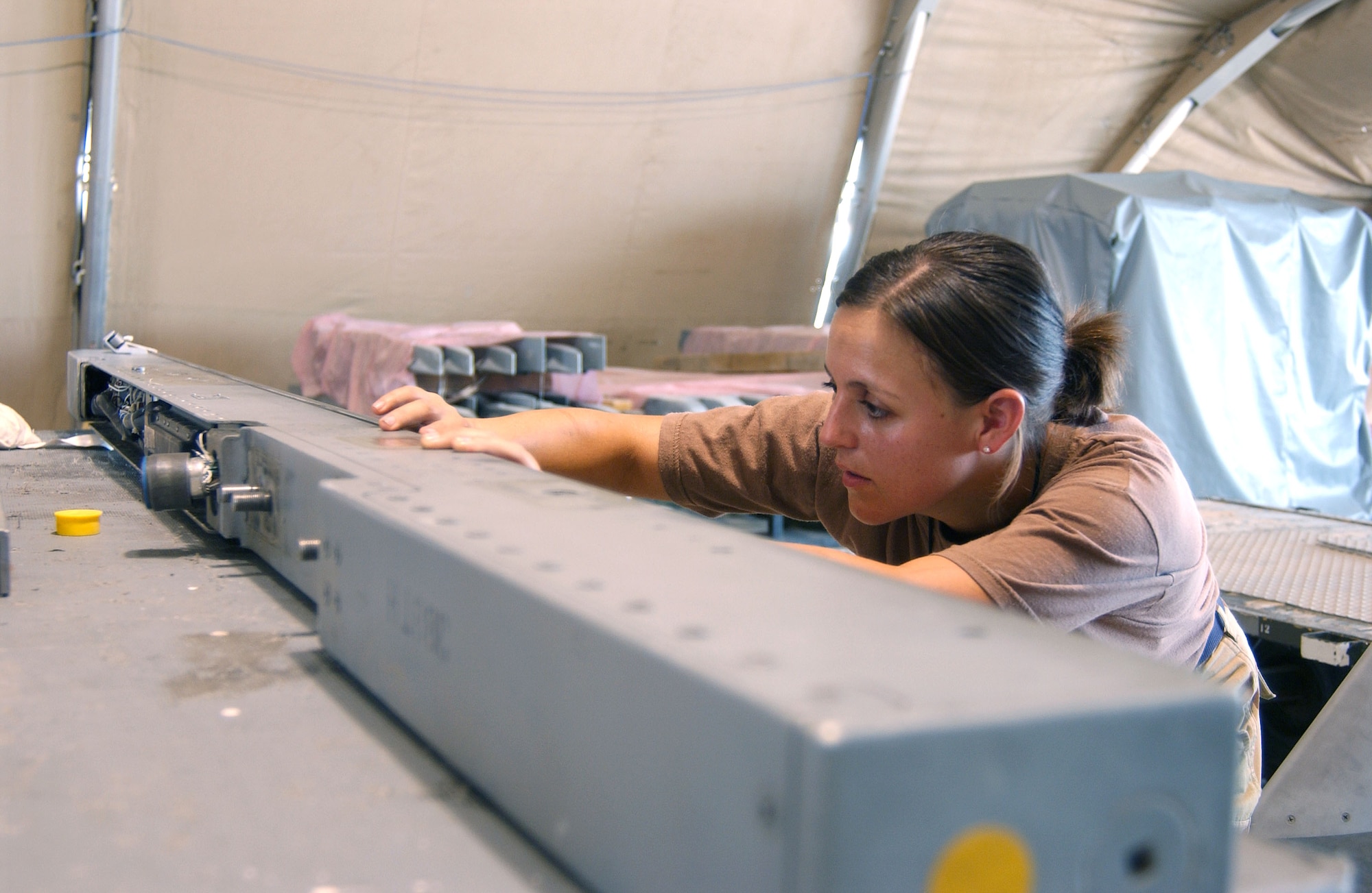Senior Airman Jean Jackson repairs a wing rail from an F-16 Fighting Falcon at Balad Air Base, Iraq. The 332nd Expeditionary Maintenance Squadron Armament Flight is responsible for the maintenance of the system on which the F-16 carries its weapons.  (U.S. Air Force photo/Senior Airman James Croxon)