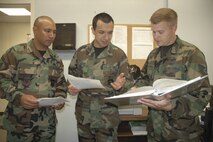MINOT AIR FORCE BASE, N.D. -- Left to right: Senior Master Sgt. Jose Pascua, 5th Comptroller Squadron superintendent, 1st Lt. Juan Guzman, 5th CPTS deputy financial services officer, and Staff Sgt. Philip Chapman, 5th CPTS budget and accounting technician, review funding documents for a purchase request for an automatic car wash at the 5th CPTS Budget office Wednesday.(U.S. Air Force photo by Airman 1st Class Ross Tweten)