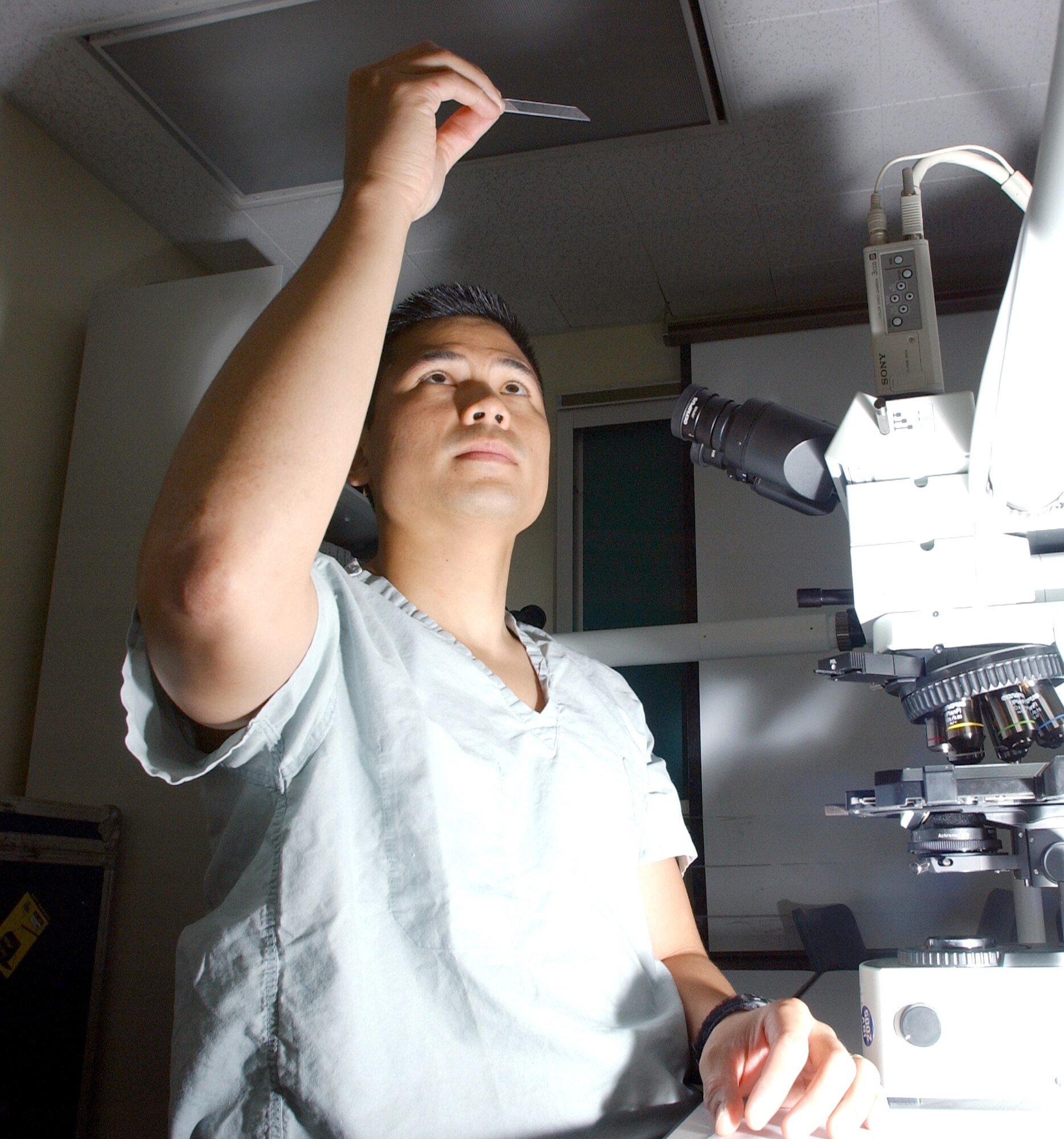 Capt. Oliver Wisco prepares a specimen slide for viewing under a microscope at the Wilford Hall Medical Center at Lackland Air Force Base, Texas, Aug. 27. Captain Wisco is a dermatology resident with 59th Medical Wing's dermatology clinic. (U.S. Air Force photo/Master Sgt. Kimberly Yearyean-Siers)