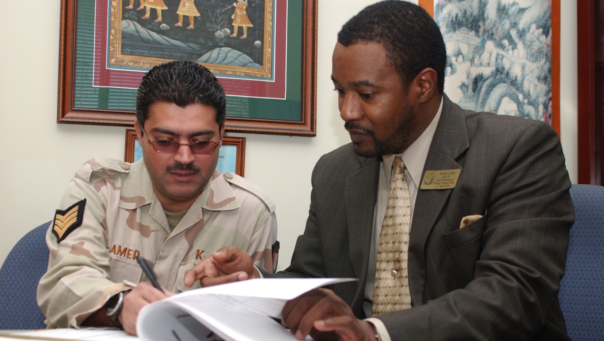 Kuwaiti Air Force Staff Sgt. Khaled Al-Amer is guided through in-processing paperwork by James Cooks Jr., chief of the Keesler International Military Student Office. The sergeant is the first international student to report to Keesler for training since Hurricane Katrina. (U.S. Air Force photo by Kemberly Groue)