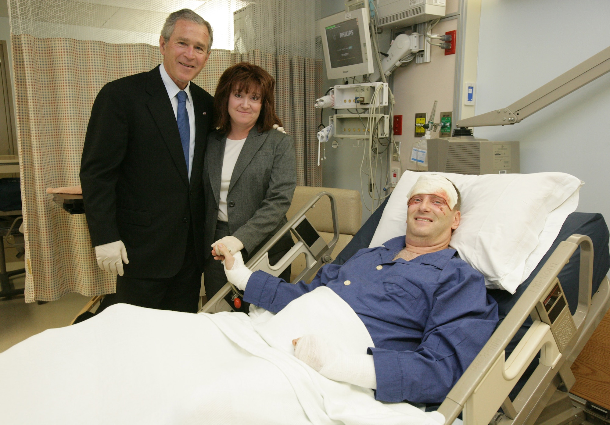 President George W. Bush visits with Maj. Marc Montgomery, 96th Flying Training Squadron, Laughlin AFB, Texas, and his wife, Kathleen, Jan. 1, at the Brooke Army Medical Center, San Antonio. Major Montgomery, an instructor pilot at Laughlin, was injured in a T-38C mishap Dec. 13. (White House photo by Shealah Craighead)