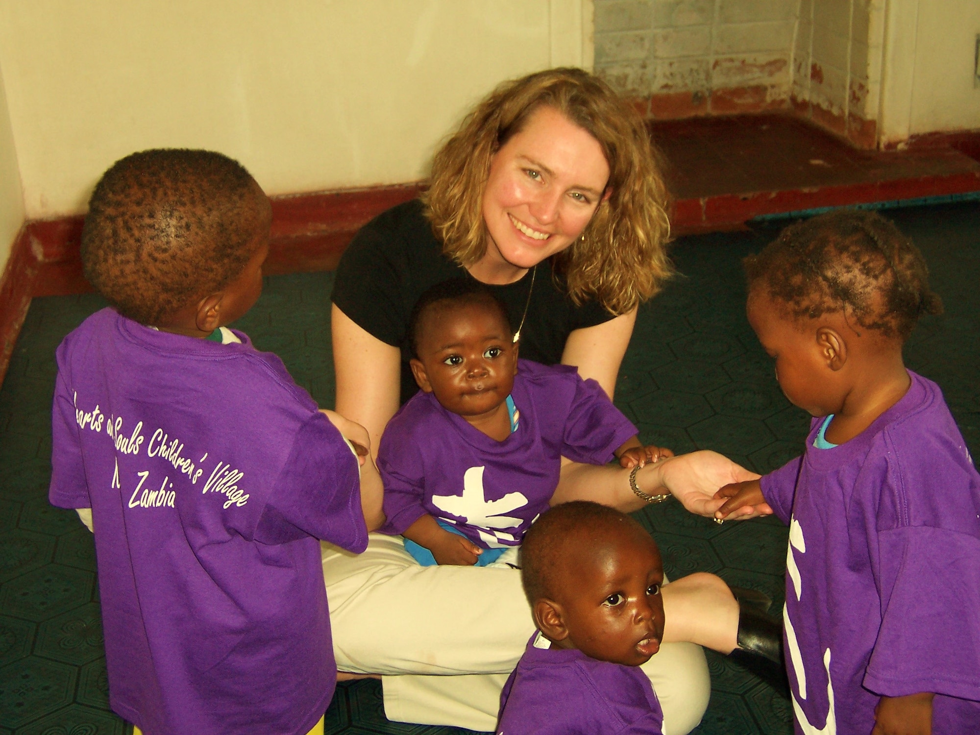 Mrs. Kim Milhoan plays with children in the first AIDS orphanage. The Milhoans funded both facilities with charitable donations through non-profit organizations. (U.S. Air Force photo by Col. Kirk Milhoan)