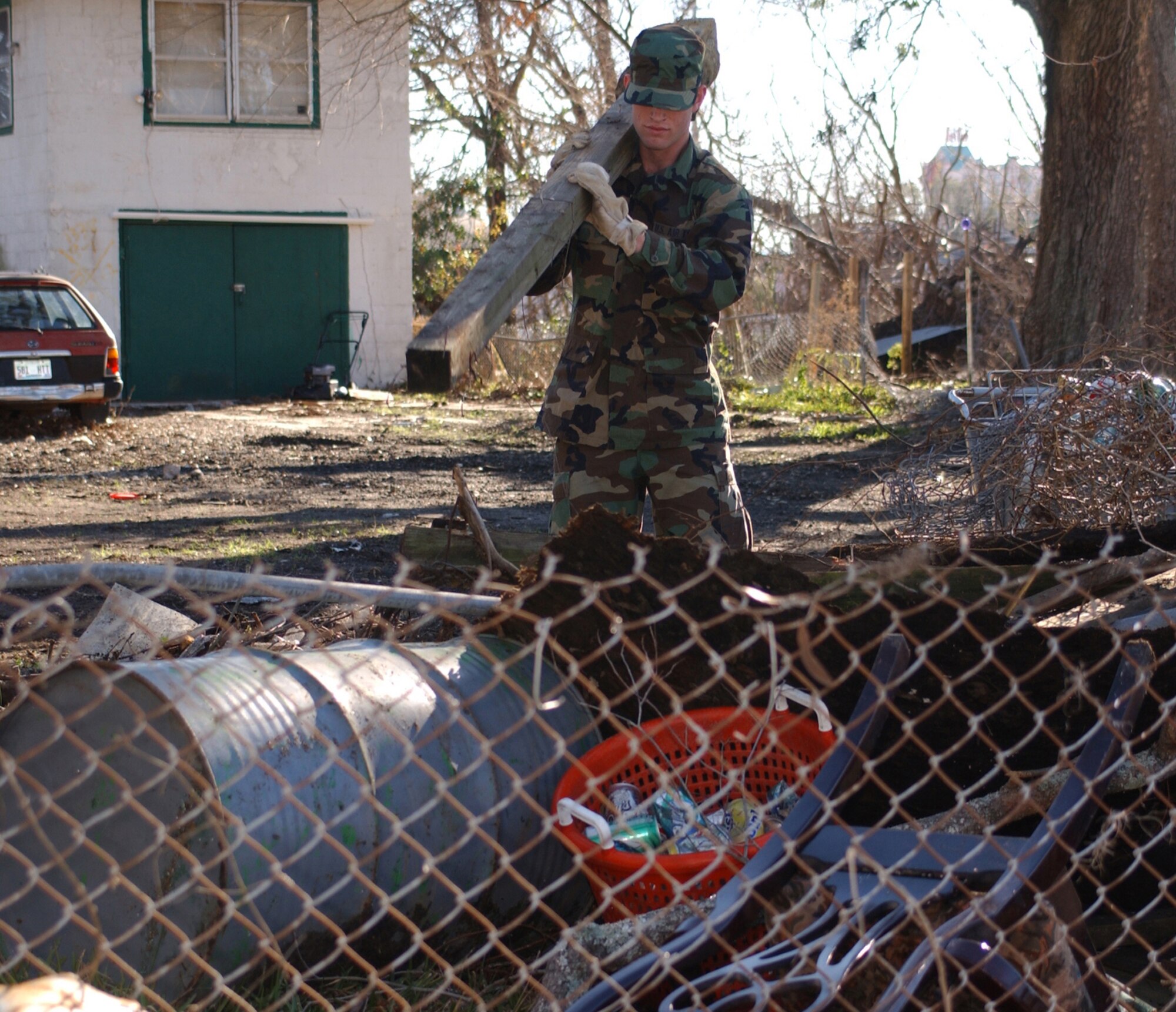 KEESLER AIR FORCE BASE, Miss. (AETCNS) -- Airman Basic Daniel German, 338th Training Squadron, and a team of other student volunteers clean hurricane debris from a home on Crawford Street in Biloxi Jan. 18. (U.S. Air Force photo by Kemberly Groue) 