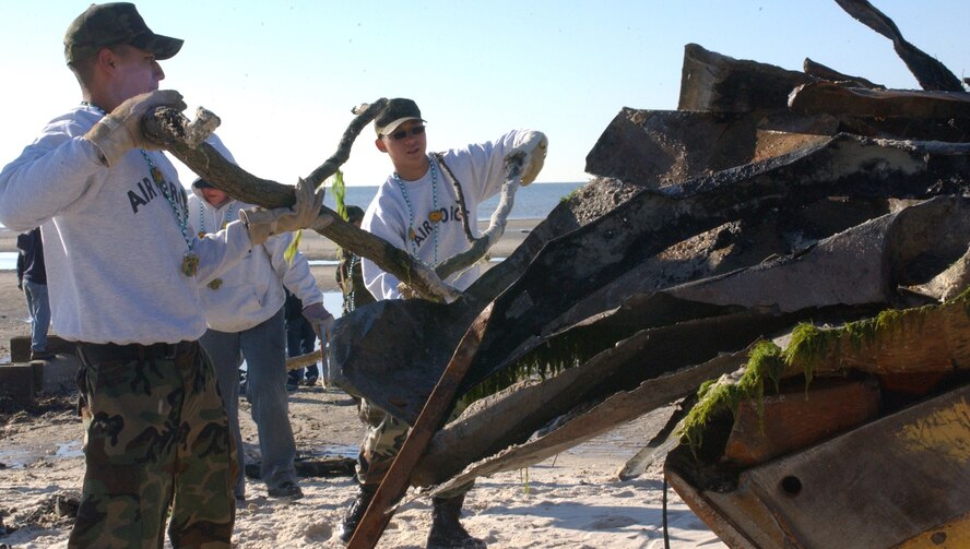 KEESLER AIR FORCE BASE, Miss. (AETCNS) -- Airmen 1st Class Pedro Rivera, left, and Gia Nguyen, 81st Transportation Squadron, load debris in the front end loader of a tractor Feb. 13 during a beach cleanup in Biloxi. In addition to the 220 Biloxi volunteers, another 140 volunteers from Keesler and other area military installations worked on beach debris removal Feb. 11 in Hancock County. (U.S. Air Force photo by Kemberly Groue)