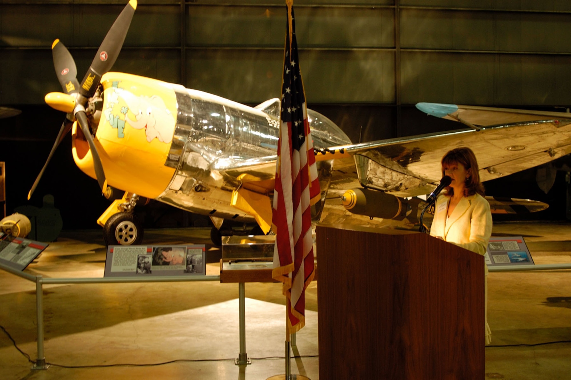 DAYTON, Ohio (8/24/06) -- Kelly Rooker speaks during the P-47D unveiling at the National Museum of the United States Air Force. The restored P-47D was marked by the museum's restoration staff to represent the aircraft flown by her father, Col. Joseph Laughlin, commander of the 362nd Fighter Group, 9th Air Force, during combat operations in Europe in early 1945. (U.S. Air Force photo by Jeff Fisher)