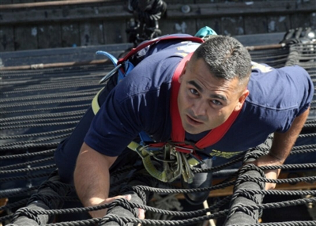 A U.S. Navy chief petty officer selectee climbs the mainmast shroud aboard USS Constitution "Old Ironsides" during the second day of CPO leadership training, Aug. 22, 2006, in Boston, Mass. Each year the ship hosts approximately 300 selectees for training, which includes sail handling, gun drill training and community outreach designed to instill leadership and teamwork skills. 