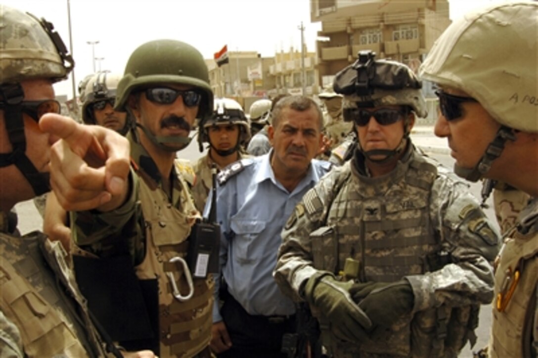 U.S. Army Col. Thomas Vail (second from right), an Iraqi police officer and the commanding officer of the 6th Iraqi Army Division discuss where to position security personnel in Baghdad, Iraq, on Aug. 20, 2006.  Vail is the commanding officer of the 506th Regimental Combat Team, 101st Airborne Division.  