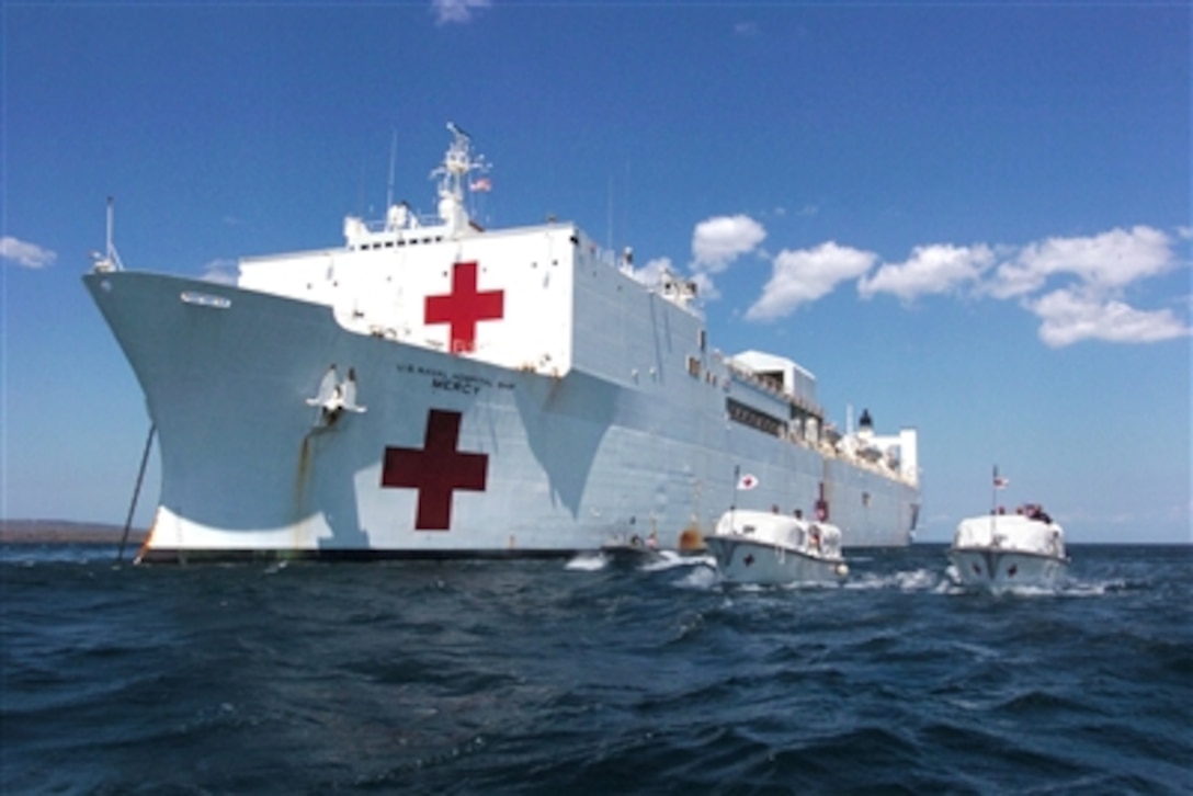 The hospital ship USNS Mercy (T AH 19) moors off the coast of the island of Kupang in West Timor, Indonesia, as Mercy's two transport boats shuttle patients and crew to and from shore on Aug. 21, 2006.  The Mercy is in the fourth month of a five-month humanitarian and civic assistance deployment to South and Southeast Asia.  