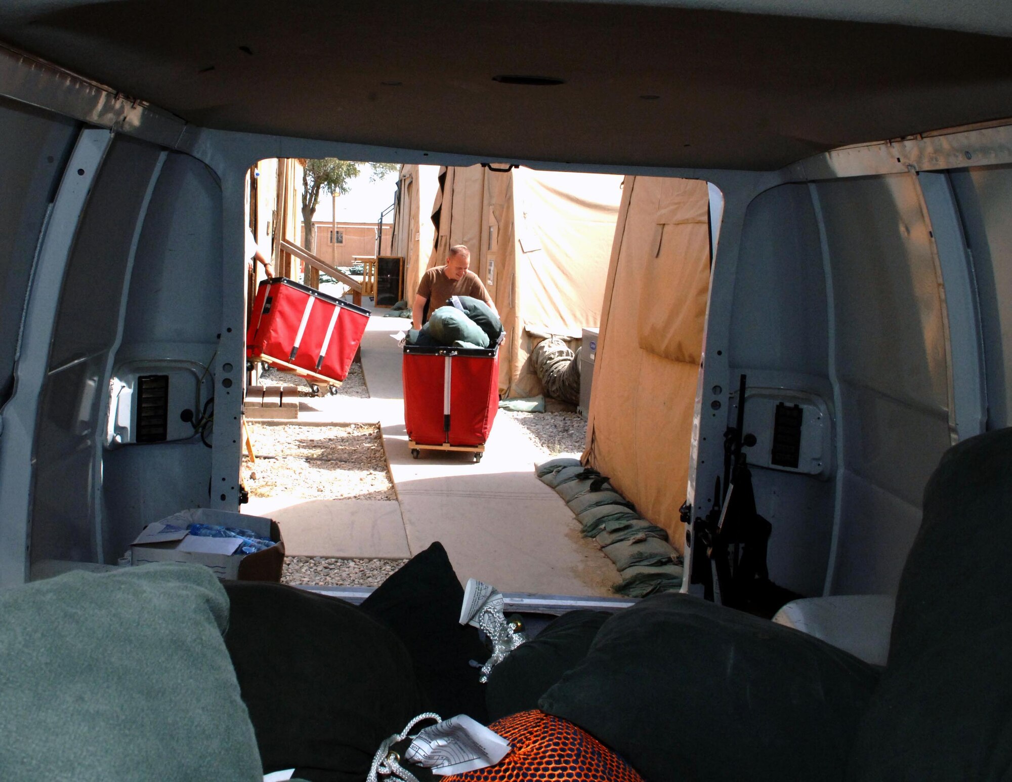 Tech. Sgt. Aaron Norfleet rolls a cartfull of dirty laundry to the van. Eventually, the van gets filled from top to bottom with bags of laundry. (U.S. Air Force photo by Master Sgt. Orville F. Desjarlais Jr.) 