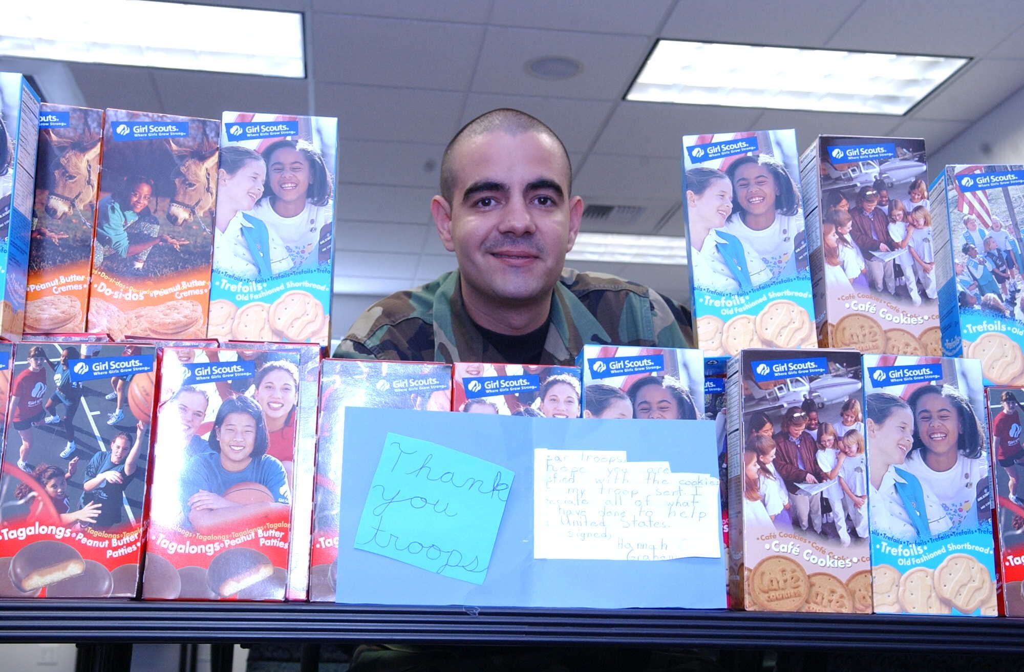 Technical Sgt. Carlos Ramossanchez, surrounded by some of the more than 250 cases of Girl Scout cookies he hands out to Team Fairchild deployers. Sergeant Ramossanchez is the Family Readiness Coordinator at the Airman and Family Readiness Center. (U.S. Air Force photo/Joe B. Wiles)