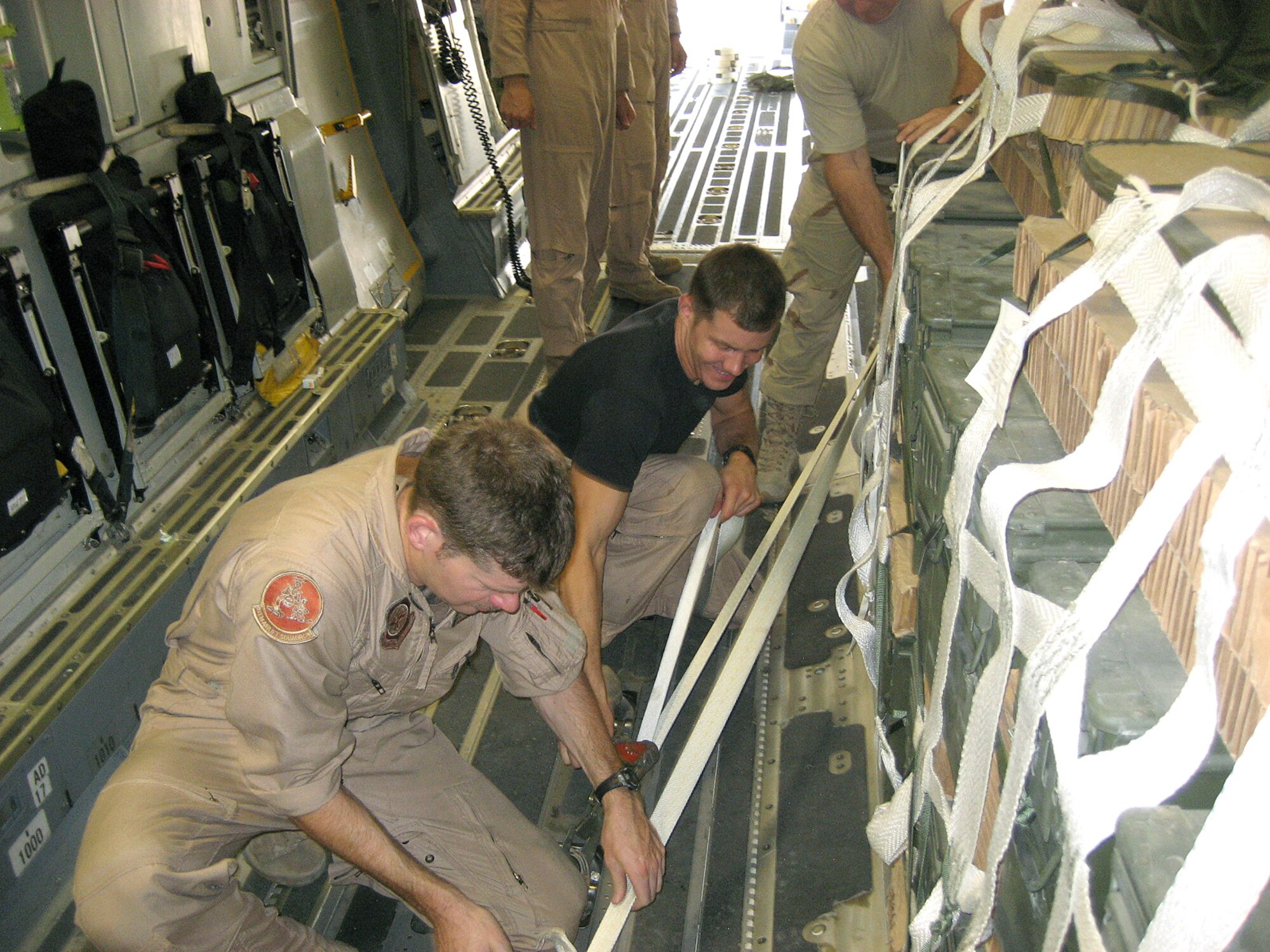 Loadmasters Tech. Sgt. Nate Gershon (front) and Senior Airman Chad Rasmussen secure a pallet of ammunition in a C-17 Globemaster III at Manas Air Base, Kyrgyzstan, Aug. 23. The 50,000-pound load went to Soldiers in Afghanistan engaged in combat with anti-coalition forces. (U.S. Air Force photo/1st Lt. David Myrick) 

