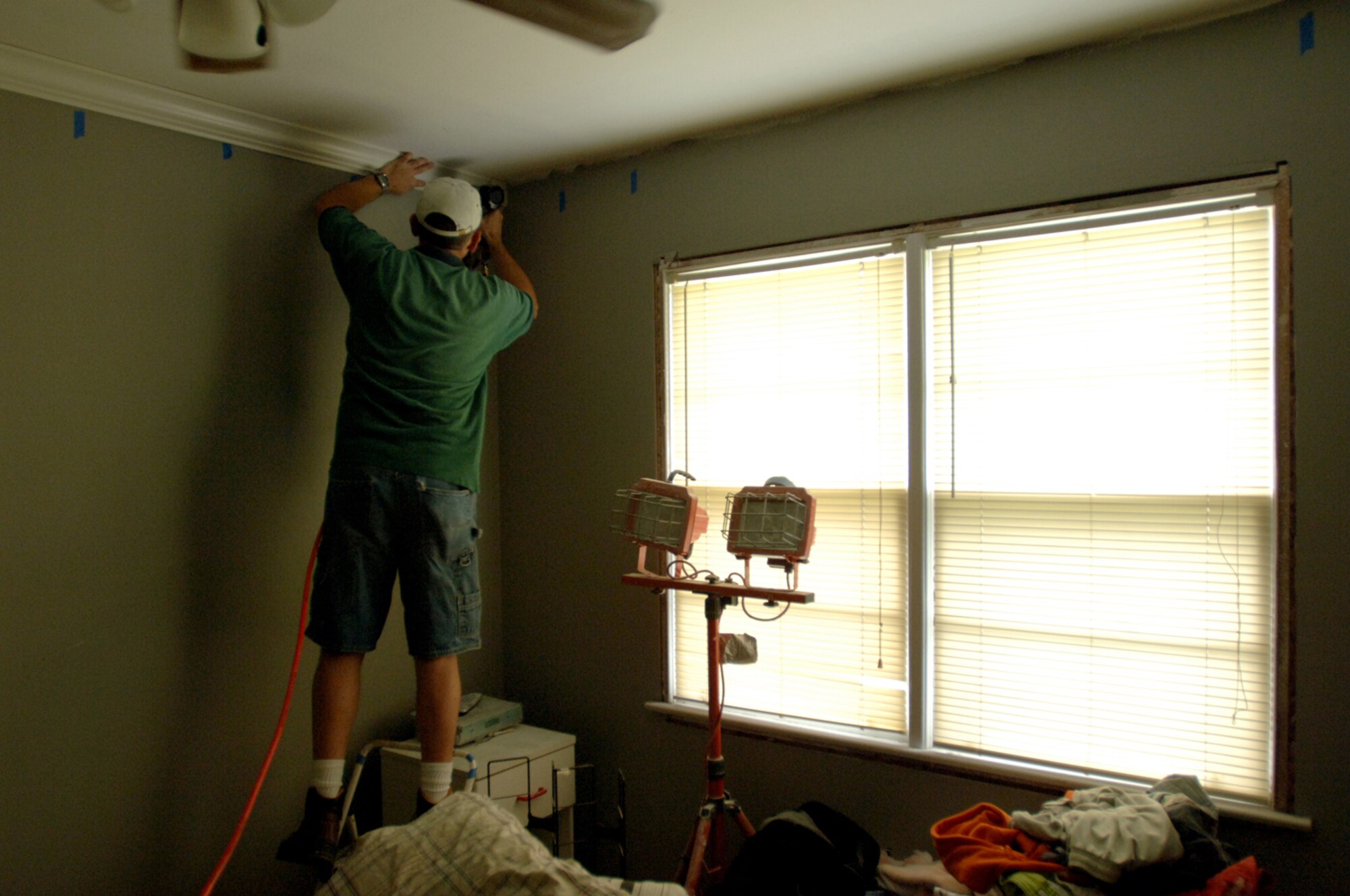 Master Sgt. Daniel Peters installs crown molding in his home in Biloxi, Miss. Sergeant Peters is one of several Airmen whose homes were severely damaged by Hurricane Katrina. Sergeant Peters is assigned to Air Force Reserve Command's 403rd Wing at Keesler Air Force Base, Miss. (U.S. Air Force photo/Tech. Sgt. Cecilio Ricardo Jr.) 
