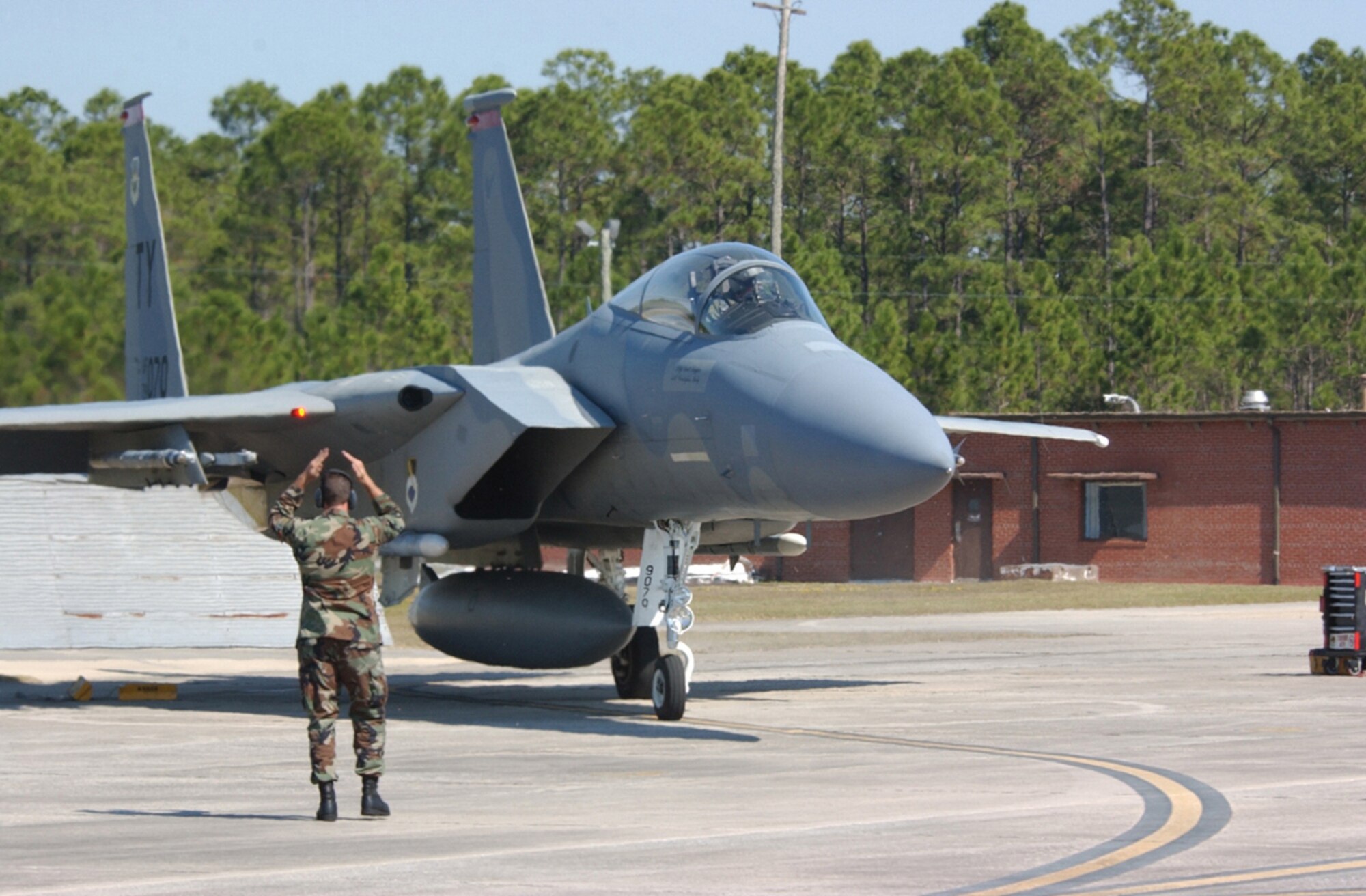 A crew chief marshals out Capt. Eric Haas, 1st FS instructor pilot, during the War Day alert scramble. After the alert horn sounded, Captain Haas and Lt. Col. Bert Dreher, 1st FS commander, scrambled to their jets and were ready for takeoff in only 3 minutes, 15 seconds. (U.S. Air Force photo by 2nd Lt. William Powell)