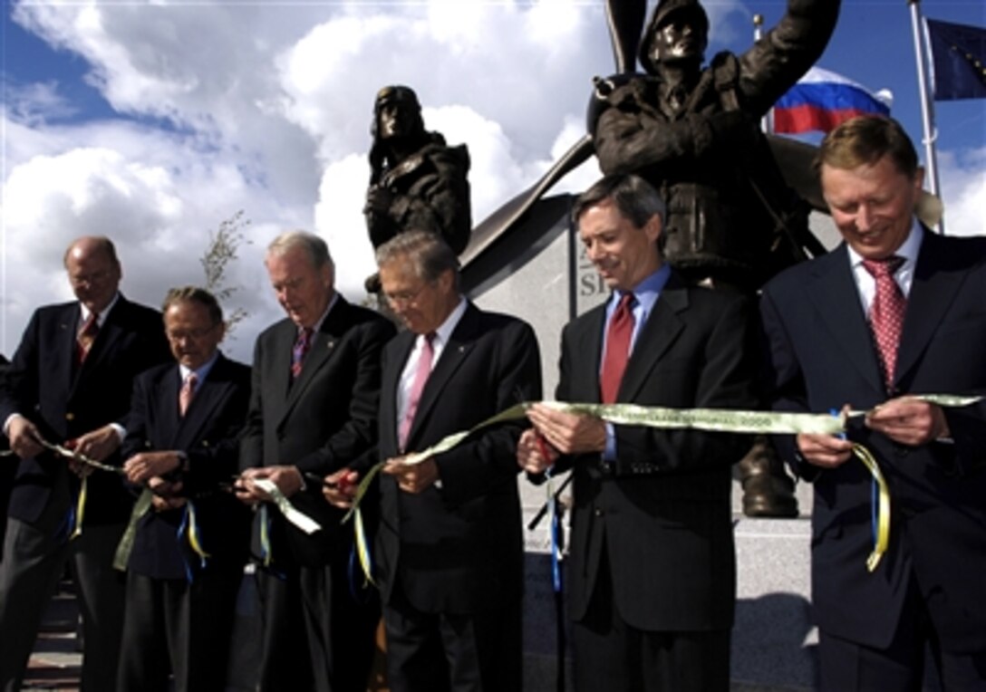 Alaskan State Sen. Gary Wilken, Sen. Ted Stevens, Gov. Frank Murkowski, Defense Secretary Donald H. Rumsfeld, former Alaskan senator John Binkley, and Russian Defense Minister Sergei Ivanov cut the ribbon dedicating a memorial to the Alaska-Siberia Lend Lease program in Fairbanks, Alaska, Aug. 27, 2006. 