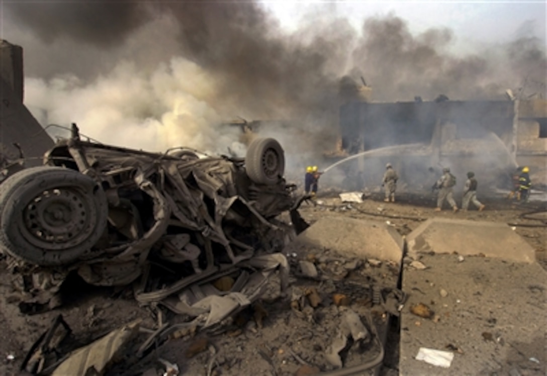 Firemen and U.S. soldiers arrive on scene after a Vehicle Born Improvised Explosive Devise (VBIED) exploded on a street outside of the Al Sabah newspaper office in the Waziryia district of Baghdad, Iraq, Aug. 27, 2006.  The VBIED destroyed more than 20 cars, killing two people and wounding as many as 30. 