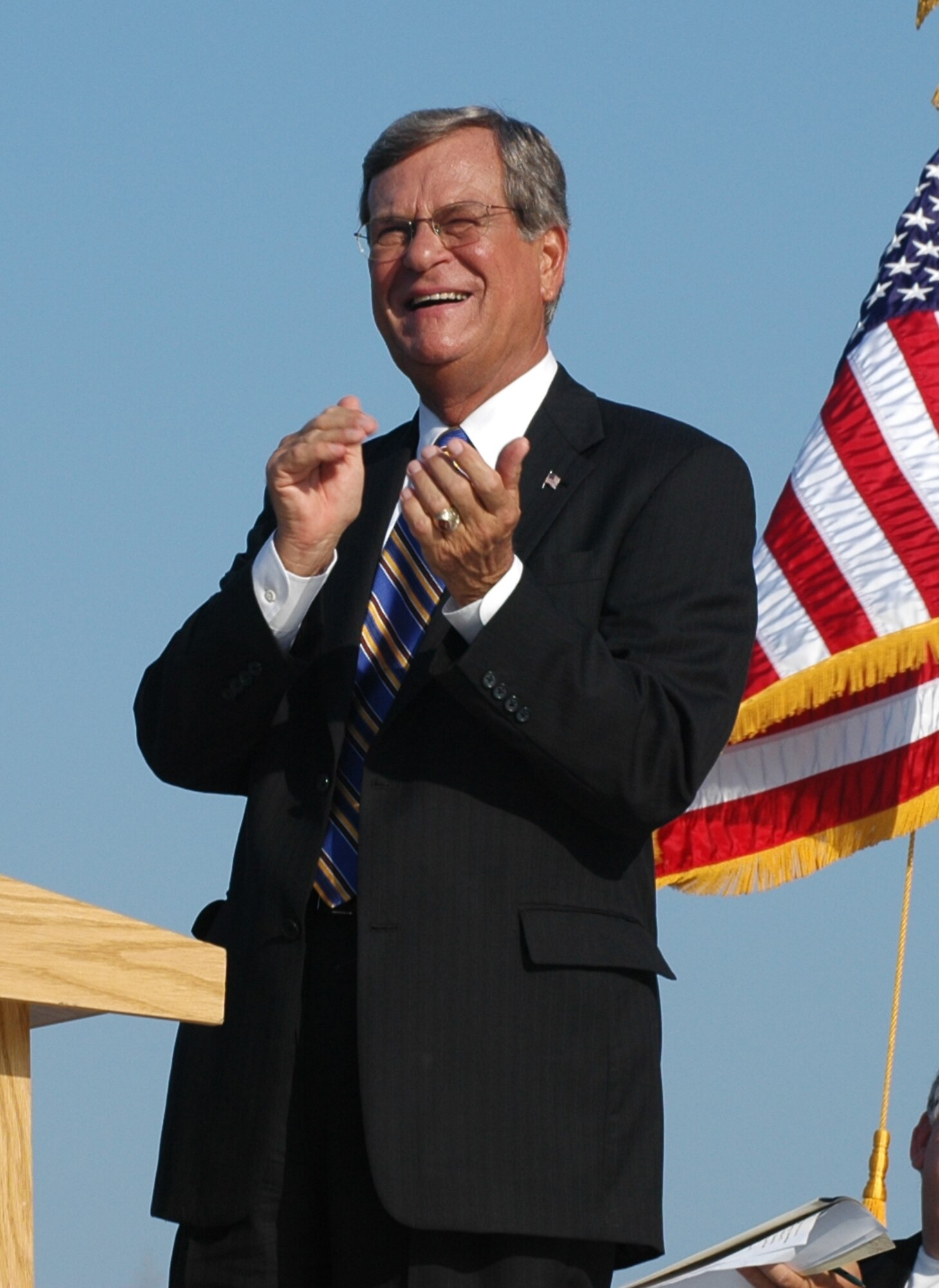 Senator Trent Lott, applauds as a WC-130J "Hurricane Hunter" passes over the crowd during his speech to the people of Biloxi, Miss. during ceremonies in memory of Hurricane Katrina. Senator Lott thanked the men and women of the 53rd Weather Reconnaissance Squadron for the important role they play in homeland security and in saving lives by providing critical data to the National Hurricane Center. 