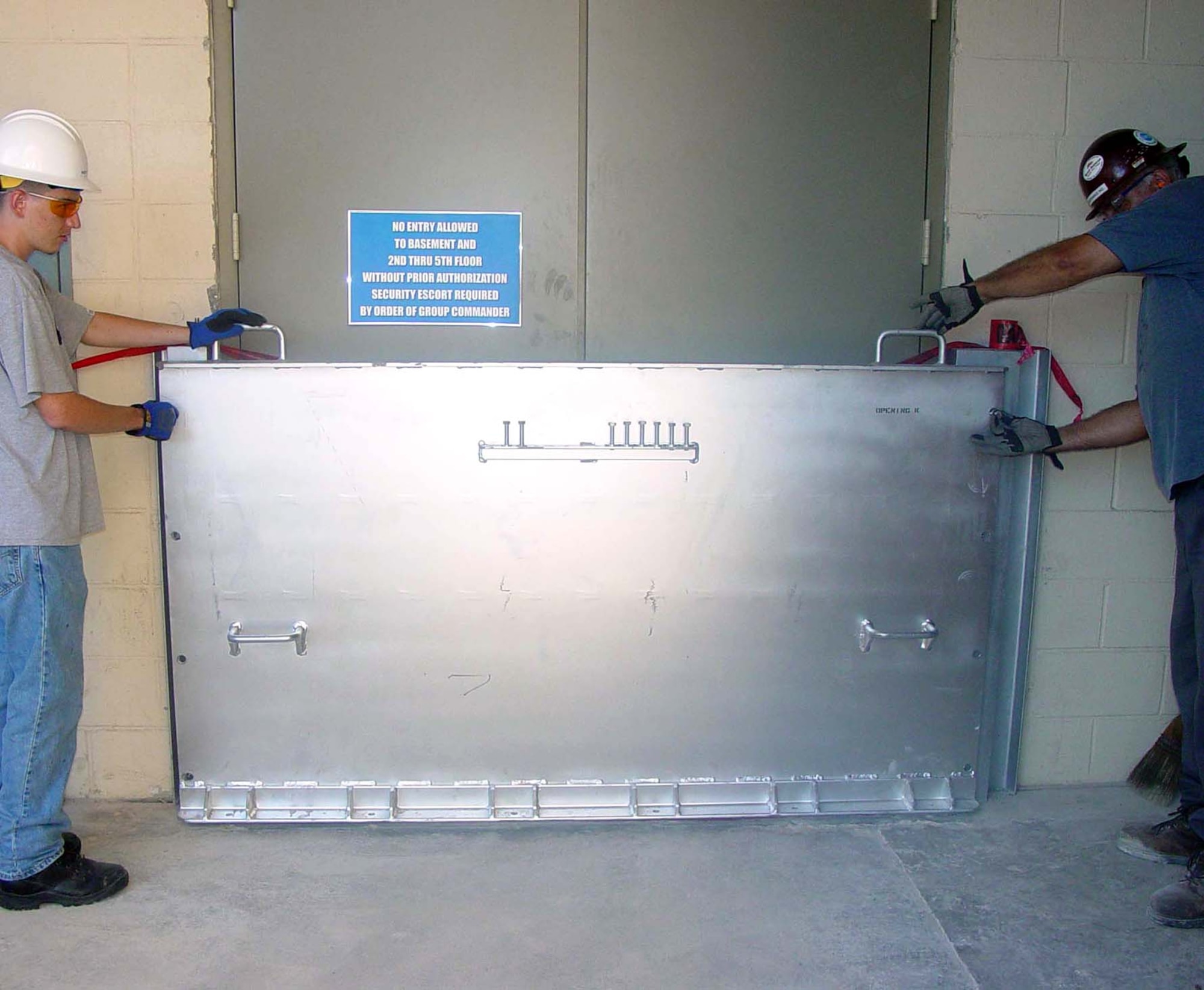 Josh Spurlin, left, and Paul Mitchell, contractors from Atlanta, install one of 28 custom-made flood doors at the Keesler Air Force Base, Miss., Medical Center Aug. 1. (U.S. Air Force photo)