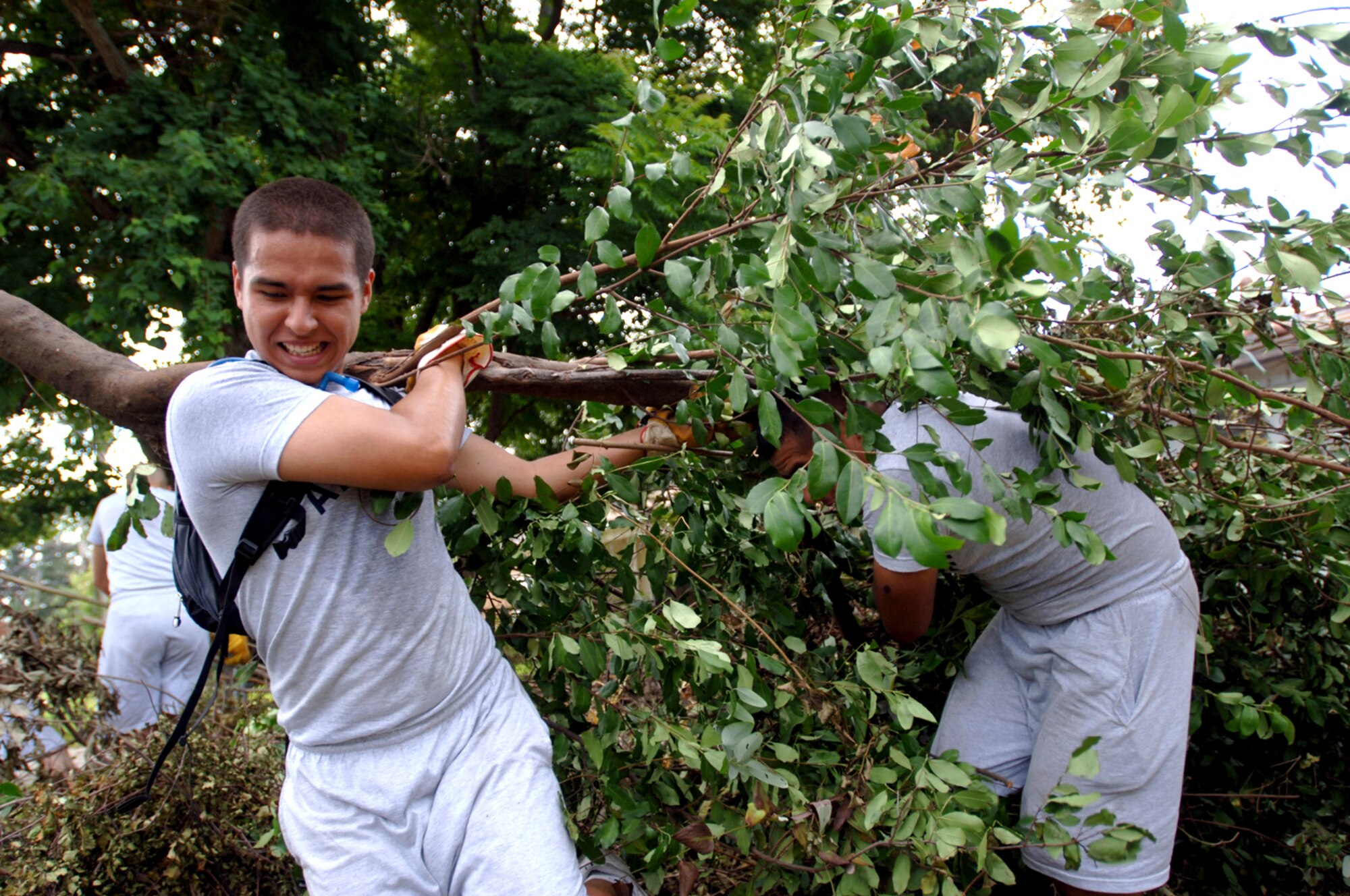 Airmen Basic Wilder Mata and Frank Morales clear the brush in the front yard of a house in Biloxi, Miss., Aug. 25. The civilian's home was heavily damaged by Hurricane Katrina one year ago. The Airmen are trainees with the 332nd Training Squadron at Keesler Air Force Base, Miss. (U.S. Air Force photo/Tech. Sgt. Cecilio Ricardo Jr.)