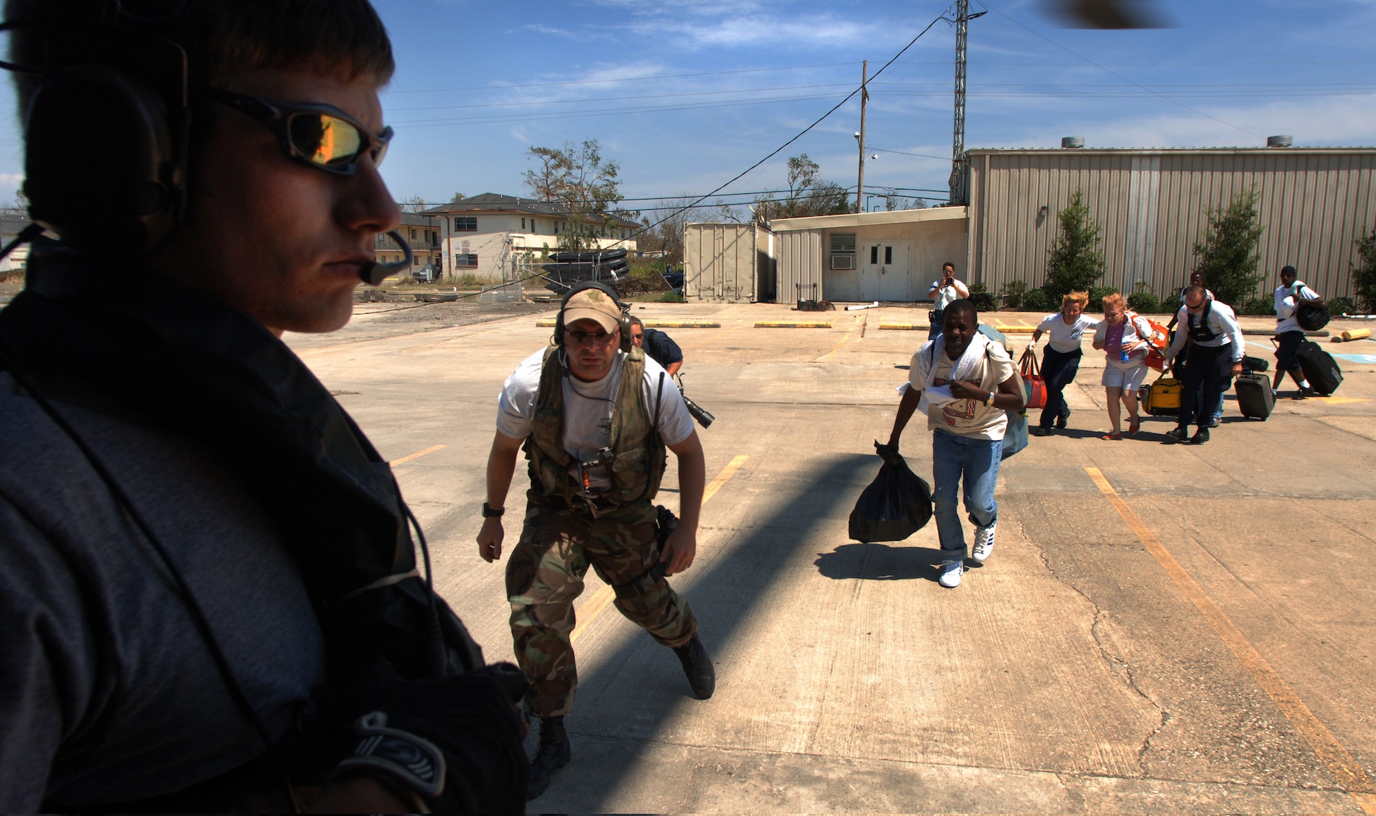 An Air Force pararescueman helps load evacuees aboard an HH-60G Pave Hawk helicopter from the 38th Rescue Squadron at Moody Air Force Base, Ga. The unit is part of the deployed 347th Expeditionary Airlift Group in Jackson, Miss. The helicopter took the evacuees to the New Orleans airport from where they will go to a relocation center somewhere in the United States. (U.S. Air Force photo by Master Sgt. Efrain Gonzalez)