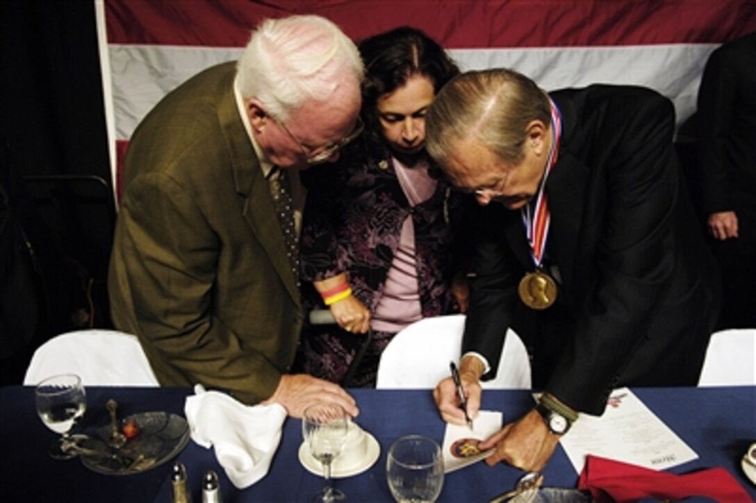 Secretary of Defense Donald H. Rumsfeld signs a program at the request of Blue Star parents at the Veterans of Foreign Wars convention in Reno, Nev., on Aug. 28, 2006.  Rumsfeld received the 2006 Veterans of Foreign Wars Dwight D. Eisenhower Award in recognition of his contributions towards securing the nation from foreign threats.  