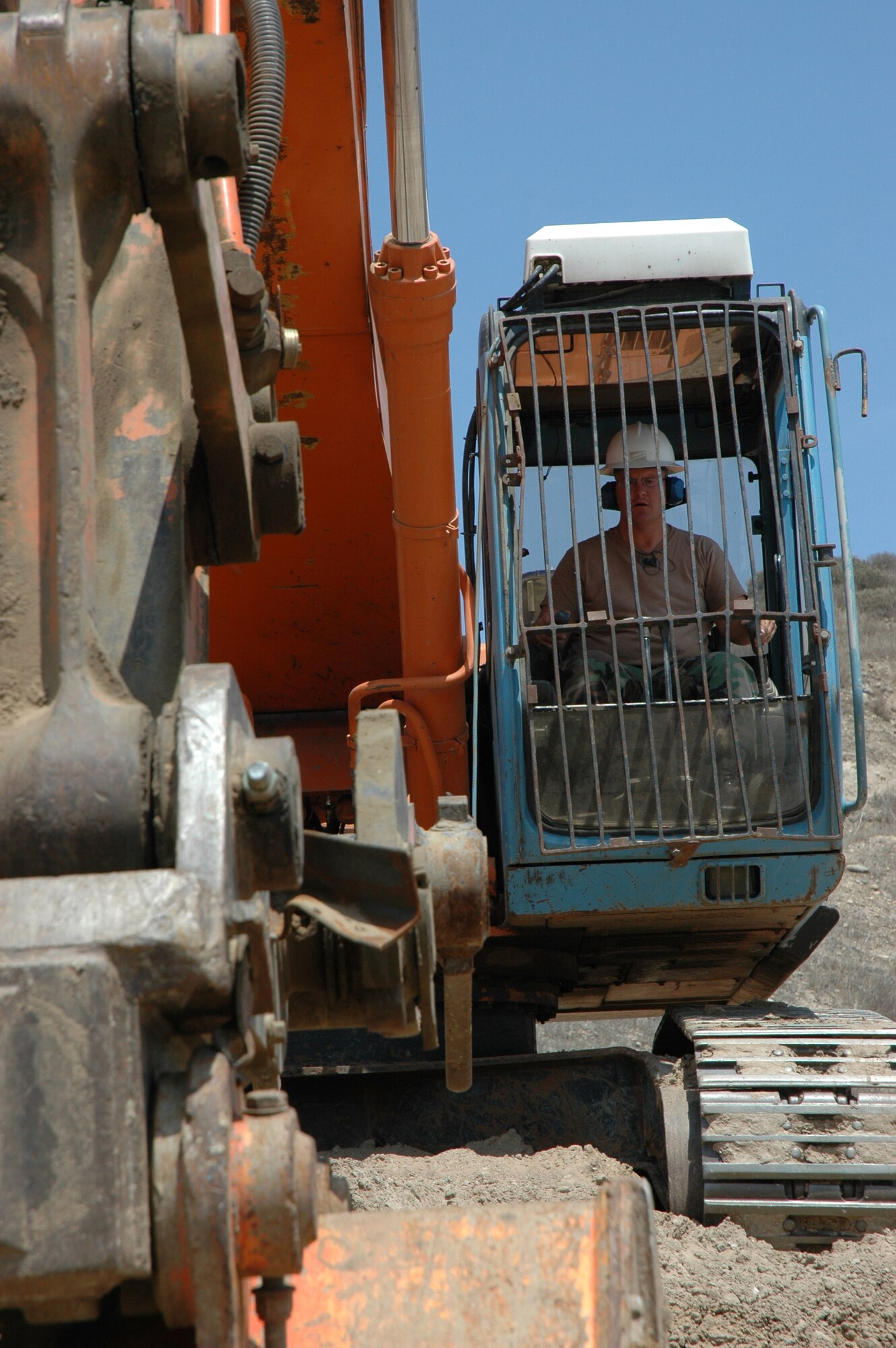 Heavy Equipment Operator Tech. Sgt. Kevin Maier, California Air National Guard civil engineer,  works an excavator at the road raising job site.  (U.S. Air Force photo by Lt. Col. Mark Moritz, 163 ARW)