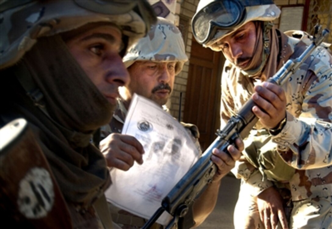 Iraqi army soldiers compare the serial number on a weapon found in a mosque to official registration documents ensuring proper registration of the weapon during a cordon and search mission in the Adhamiyah neighborhood of Baghdad, Iraq, Aug. 27, 2006. The Iraqi army soldiers were the only soldiers allowed to search the mosque.