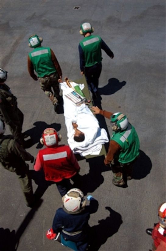 U.S. Navy sailors carry a patient to an MH-60S Knighthawk helicopter on the flight deck of the hospital ship USNS Mercy (T-AH 19) on Aug. 29, 2006.  Mercy is anchored off the coast of Dili, East Timor, while its crew conducts humanitarian and civic assistance missions as part of a five-month deployment to South and Southeast Asia and the Pacific Islands.  