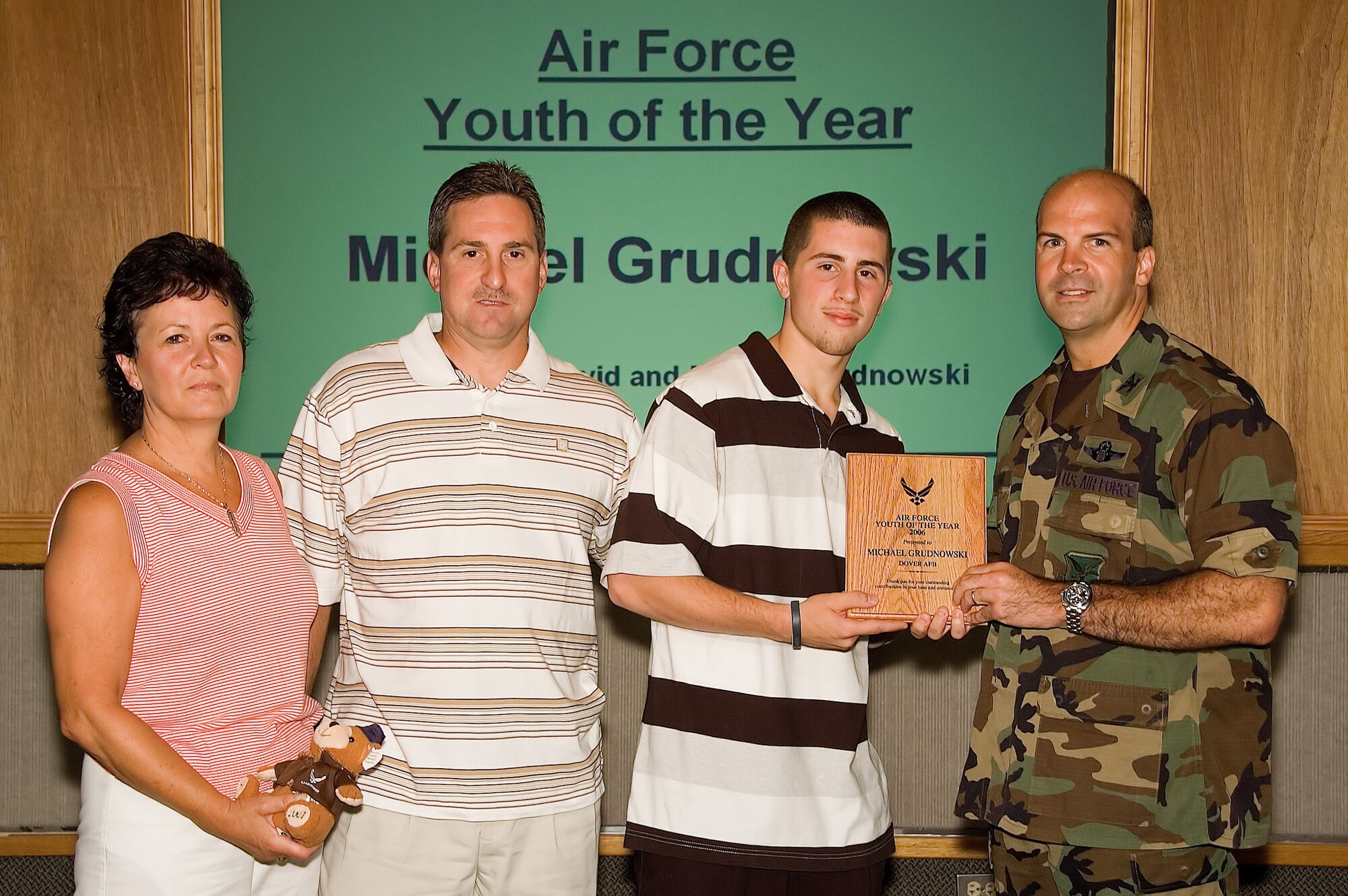 DOVER AIR FORCE BASE, Del. -- Michael Grudnowski (right center), son of Marilyn and David  Grudnowski (left and left center), is awarded the Delaware Boys and Girls Club and Dover Air Force Base Youth of the Year by Col. Chad Manske, 436th Airlift Wing vice commander Aug 2. (U.S. Air Force photo/Roland Balik)
