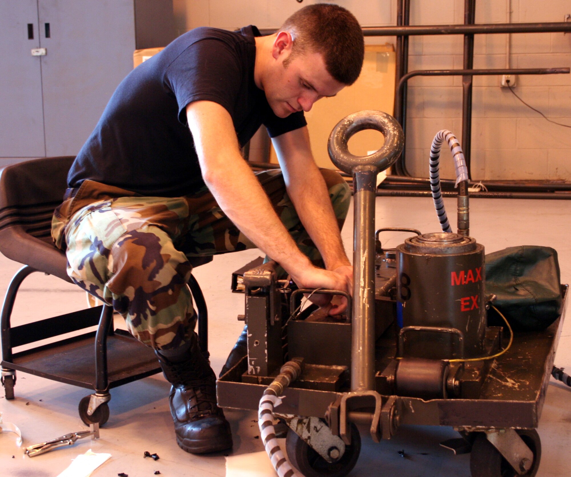 Senior Airman Ruben Woodruff, 16th EMS AGE, does a phase inspection on an axle jack. (U.S. Air Force Photograph by Dylan Laurie)