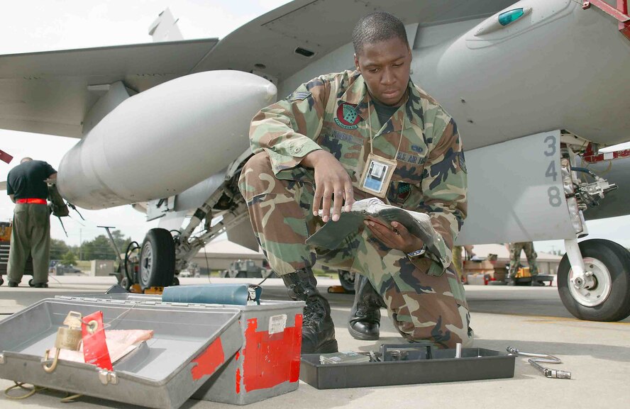 Senior Airman Quincy Dunbar, 77th Aircraft Maintenance Unit aviation specialist, reads his technical manual prior to maintenance on an F-16 aircraft. (U.S. Air Force photo/Senior Airman John Gordinier)