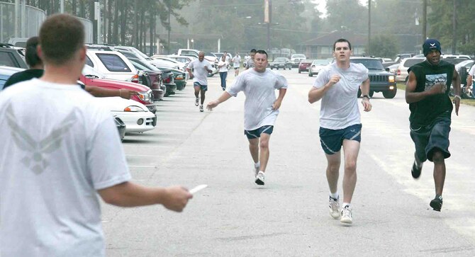 SHAW AIR FORCE BASE, S.C.-- Airman 1st Class Paul Strickland, 20th Equipment Maintenance Squadron, hands out playing cards to the runners during the 5K Poker Run Aug. 25. The 20th Services Squadron handed out trophies to the top three fastest runners in the men's and women's group. Each runner was handed a playing card from five postions throughout the run and the two runners with the best poker hands won a prize.  (U.S. AIr Force photo/Senior Airman John Gordinier)