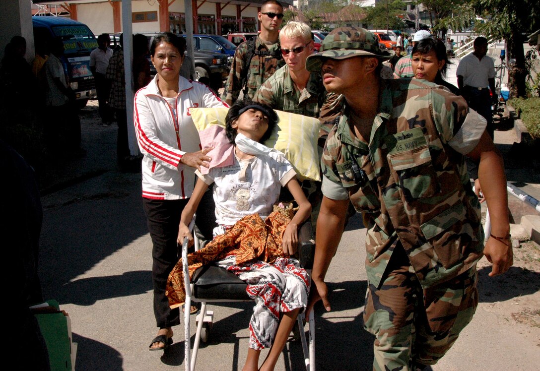 U.S. Navy Petty Officer 2nd Class Xavier Medina helps transport a patient from Johannes General Hospital in Kupang, Indonesia, to the hospital ship USNS Mercy, Aug. 22, 2006. 