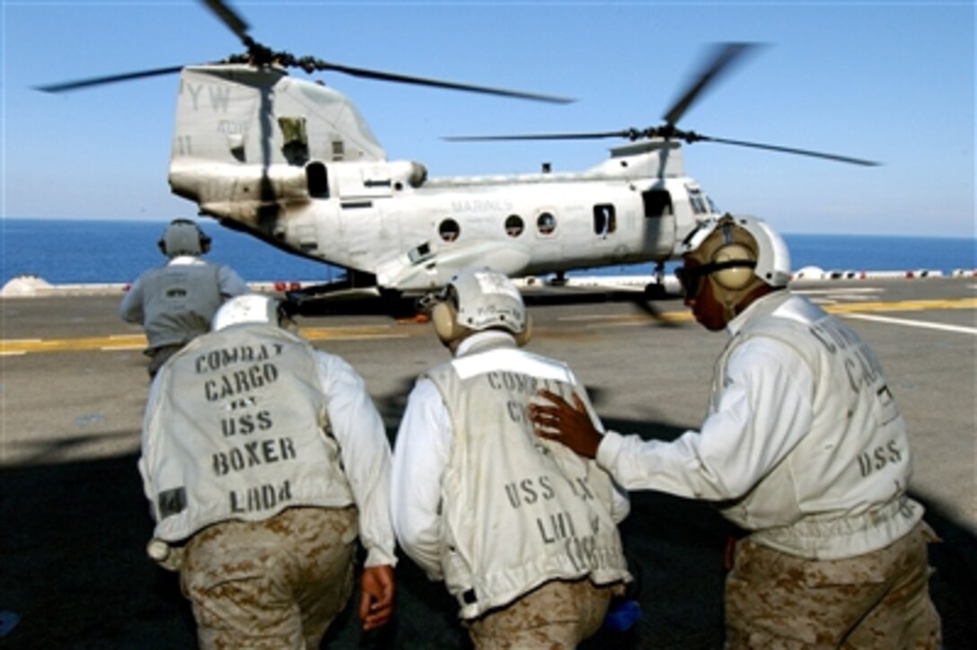 U.S. Navy combat cargo crewmembers prepare to offload simulated wounded Marines during a mass casualty drill on the flight deck of the amphibious assault ship USS Boxer, Aug. 17, 2006. 