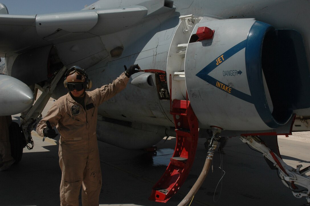 Lance Cpl. Daniel J. Calderon III signals to the fuel truck that he is ready for fuel Aug. 31 at Al Asad, Iraq. Calderon is an EA-6 fixed-wing mechanic with Marine Tactical Electronic Warfare Squadron 3, Marine Central Command. The Marines with VMAQ-3 have adopted a new fueling process that greatly reduces the time an aircraft is on the ground.