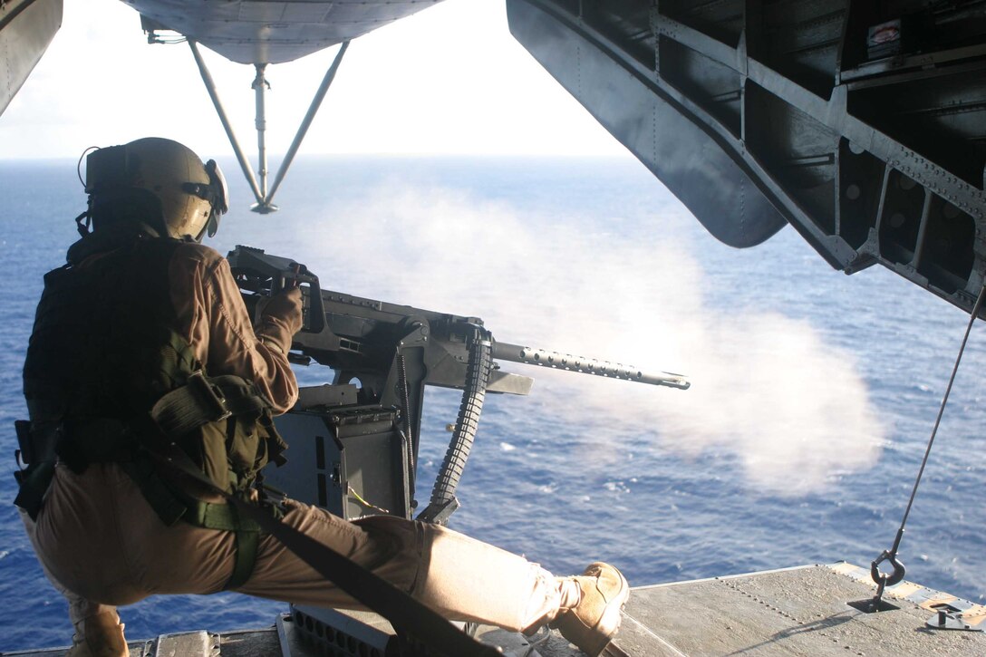 A Marine with Marine Haevy Helicopter Squadron 363, shoots a 50 caliber machine gun from the back ramp of a CH-53D, Aug. 31. This was one of the qualifications that the Marines had to go through before their upcoming deployment to Iraq in support of Operation Iraqi Freedom.