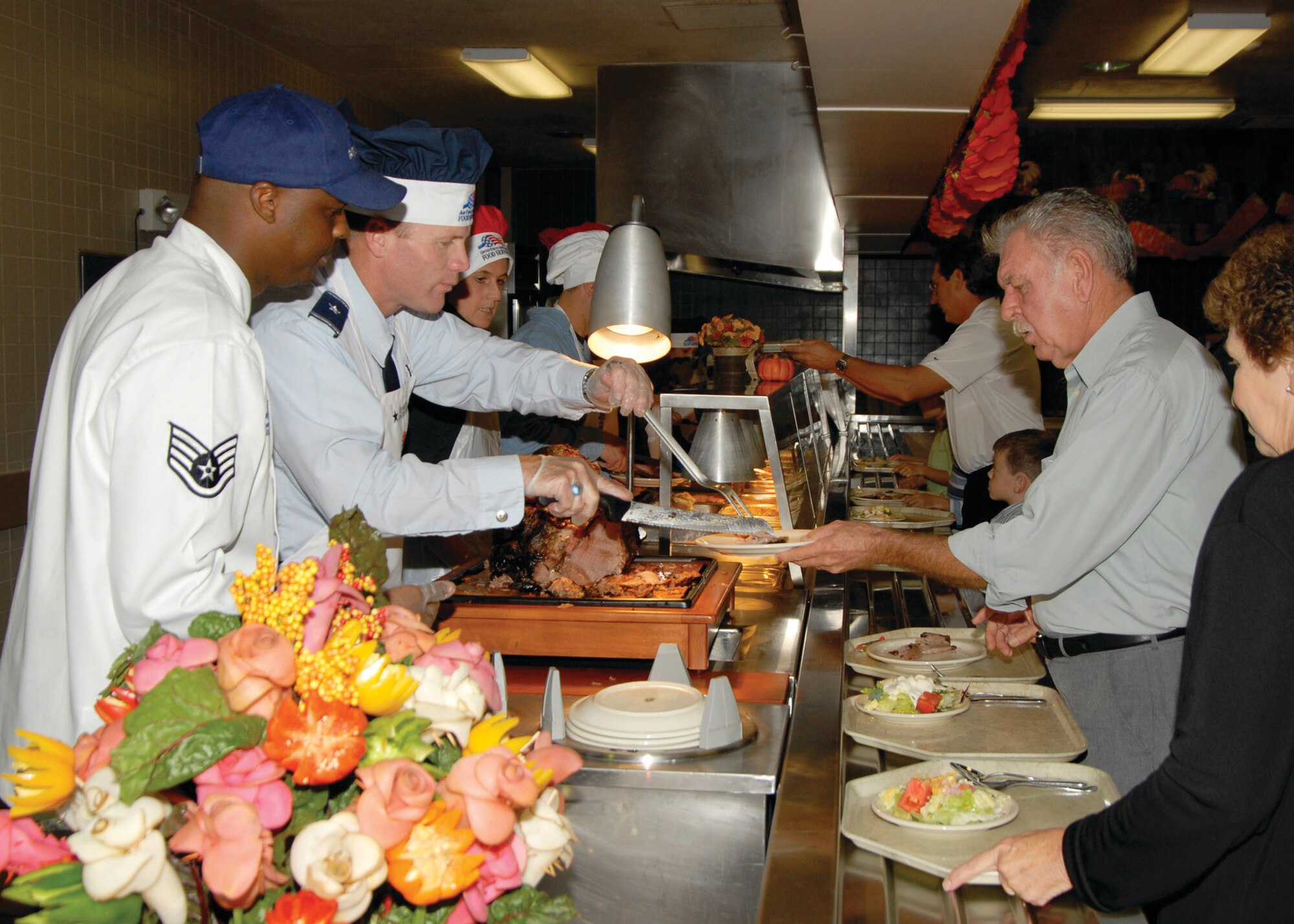 TYNDALL AIR FORCE BASE, Fla. --  Brig. Gen. Tod Wolters, center, 325th Fighter Wing commander, gives Staff Sgt. Curtis Moore, left, a break while carving the turkey for the Thanksgiving meal held Nov. 24 at the Berg-Liles Dining Facility. Approximately 146 dorm residents, shift workers, ative-duty and retired military members and their families were served. (U.S. Air Force photo by Isaac Gibson)
