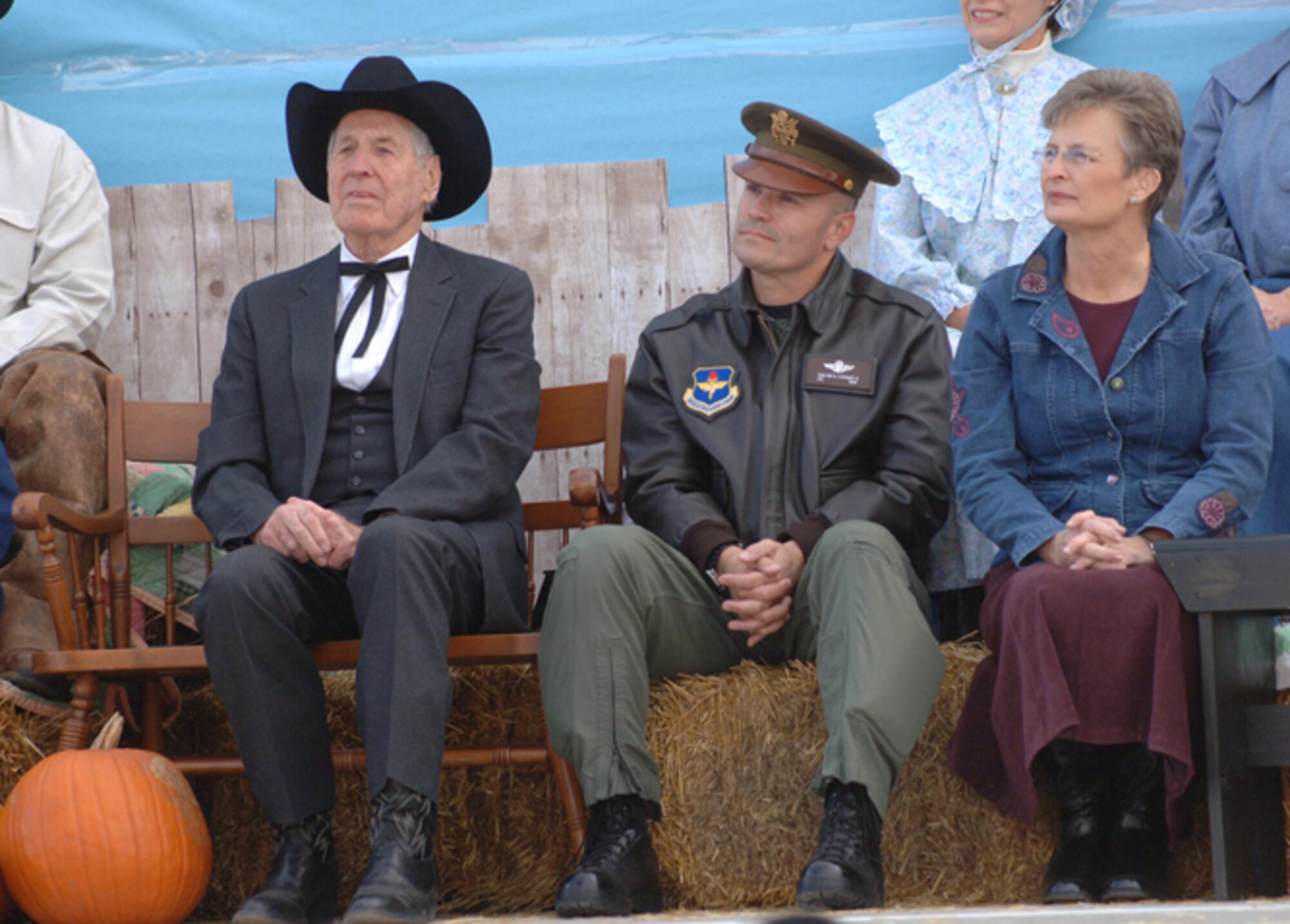 97th Air Mobility Wing Commander Col. Carlton D. Everhart II, center, Altus Mayor T.L. Gramling, left, and Altus Chamber of Commerce President Holley Urbanski, right, listen to a historical narration describing the early days of Oklahoma statehood during the Altus Centennial Kick-off Celebration Nov. 16.  Colonel Everhart wore a World War II-style wheelcap, and other participants wore period dress similar to what early settlers would have worn when Oklahoma became a state on Nov. 17, 1907.  Centennial celebration events are planned throughout the year leading up to the anniversary Nov. 17, 2007.  (U.S. Air Force photo/Staff Sgt. Monique Randolph.  