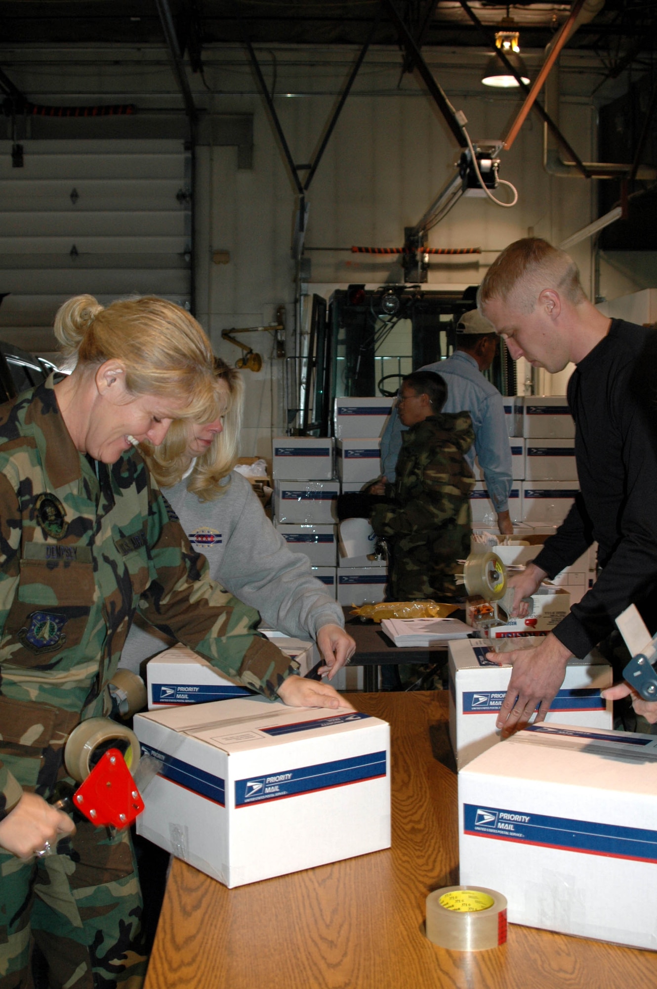 Master Sgt. Melissa Dempsey, 341st Mission Support Squadron, and Senior Airman Tony Young, 341st Logistics Readiness Squadron, tape up packages to ship to troops deployed overseas.