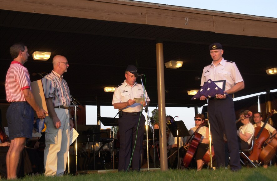 (Photo by Capt. Paula Bissonette)
Col. Bryan Benson (third from left), 71st Flying Training Wing commander, speaks during a flag exchange ceremony Monday at Meadowlake Park. Brian Hayden (left), chairman of the Enid, America Supports You campaign, and the honorable Ernie Currier (second from left), mayor of Enid, accepted a squadron flag from Maj. Robert Rossi, 71st Security Forces Squadron commander. The 71st SFS is one of two units adopted by the city as part of the Enid, America Supports You program.