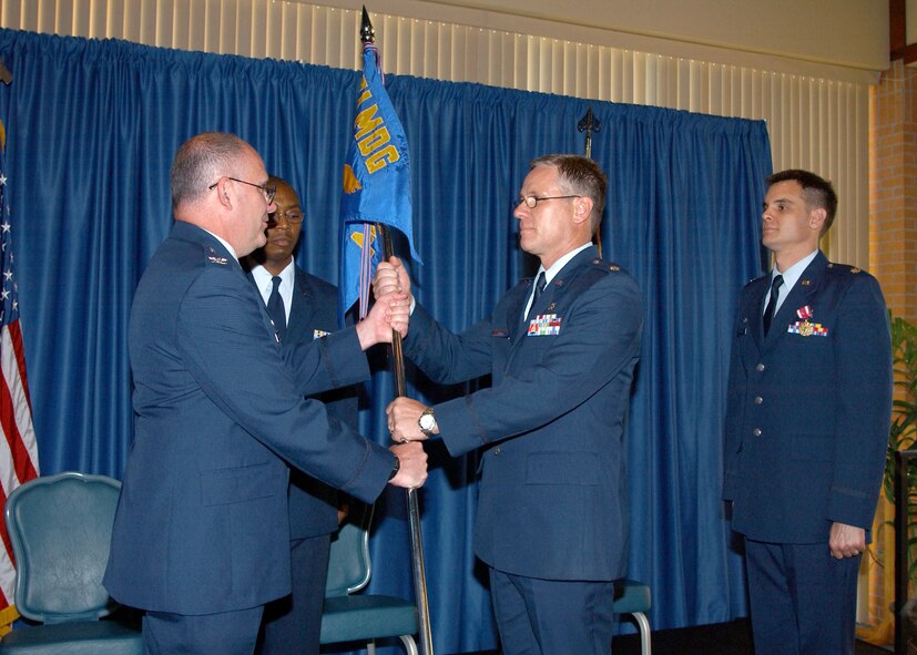 (Photo by Terry Wasson) Col. John McCafferty, 71st Medical Group commander, hands the guidon to incoming 71st Medical Support Squadron commander, Lt. Col. Jeffery Jones, Monday while the outgoing commander, Lt. Col. Jon Welch looks on. Colonel Welch will become the 509th Medical Support Squadron commander at Whiteman Air Force Base, Mo.