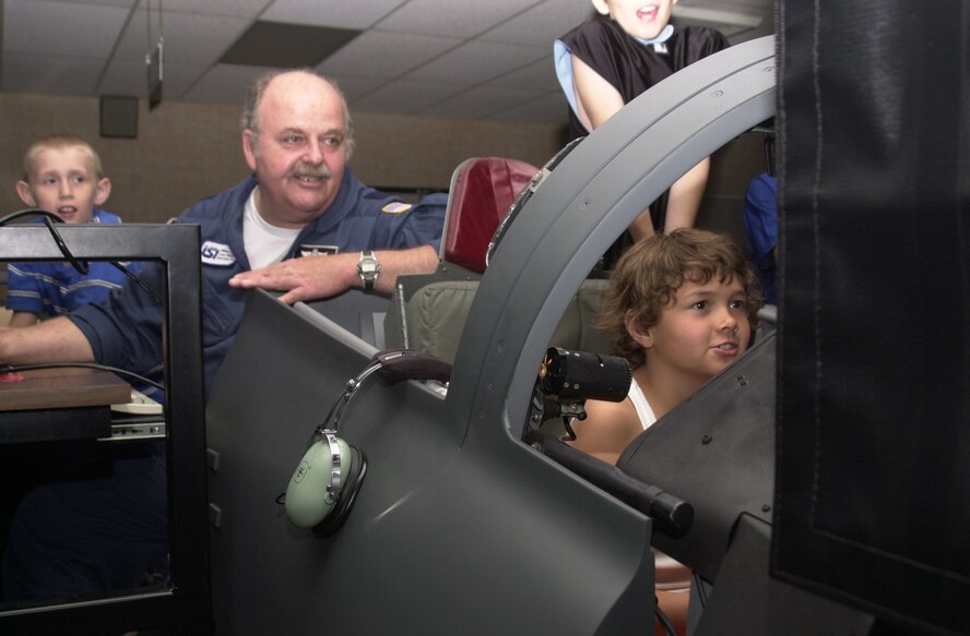 (Photo by Frank McIntyre) James Hollberg a T-38 simulator instructor with Lear Siegler Services, Inc., provides a demonstration for Camp Tomahawk participants. The two-week camp provides 40 children with the chance to participate in several on- and off-base activities with mentors and volunteers.