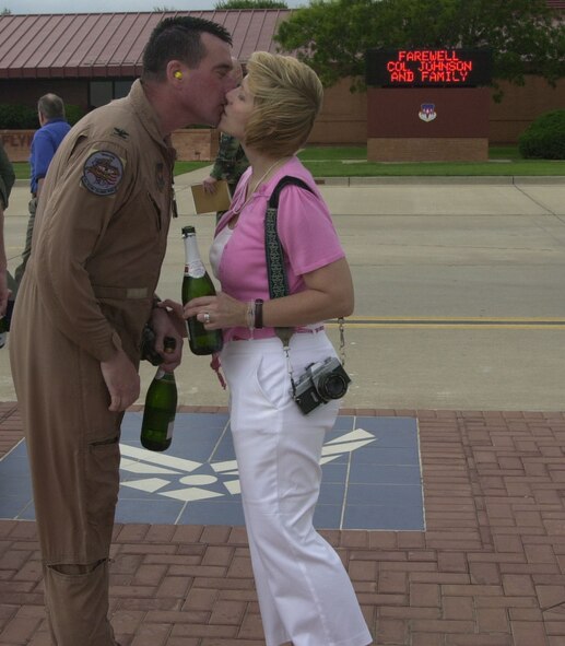 (Photo by Frank McIntyre) Colonel Johnson receives a welcoming kiss from his wife, Kathy, on the Vance flightline.