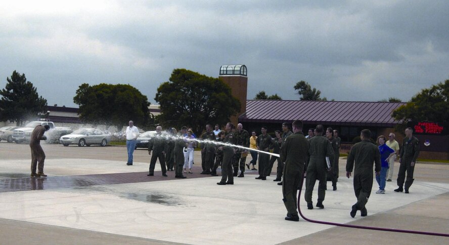 (Photo by Frank McIntyre) Col. Wade Johnson, 71st Flying Training Wing vice commander, braves the traditional farewell hose down after his fini flight in a T-37 “Tweet” June 2. 