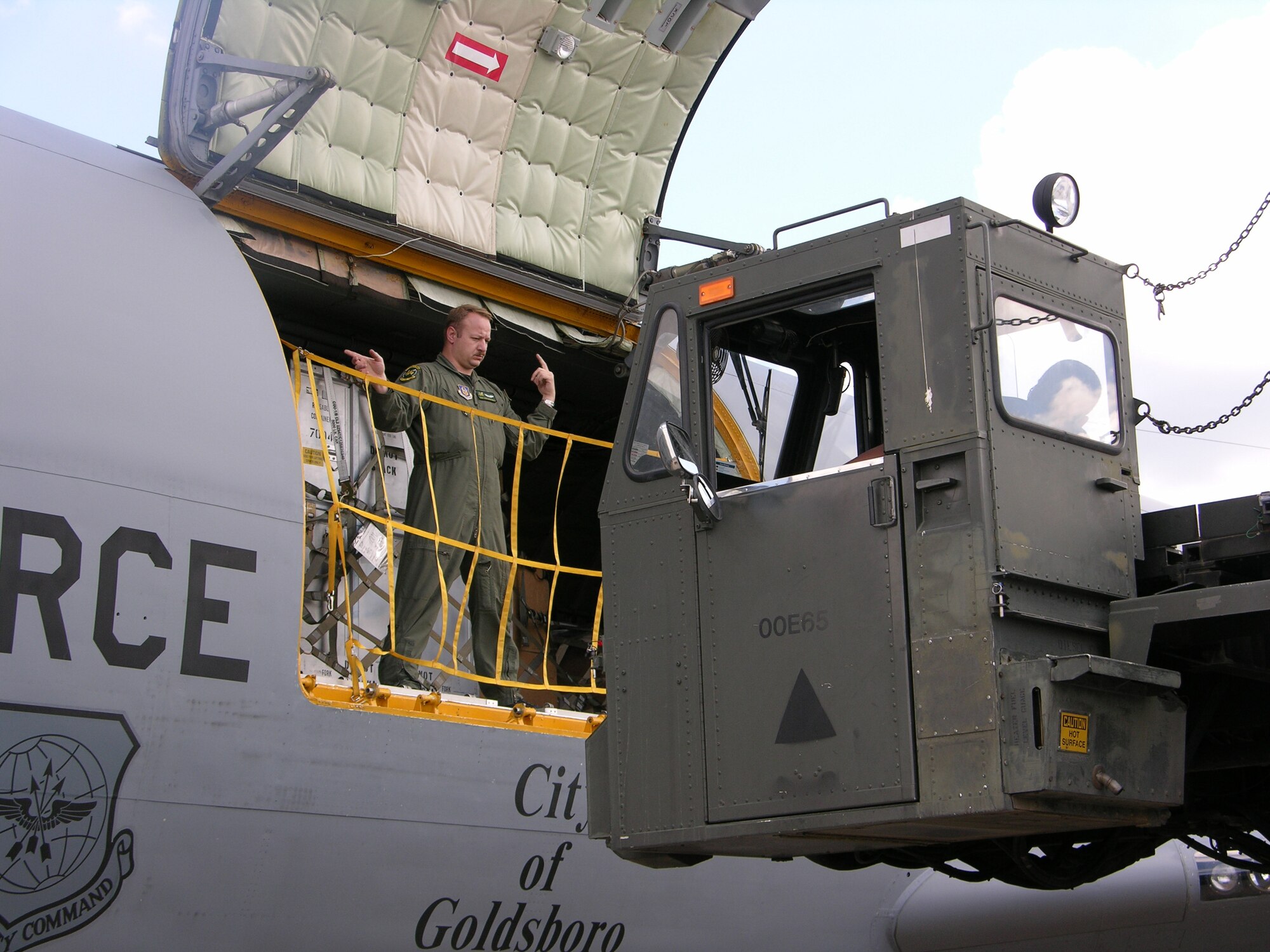 Tech. Sgt. Rich Bonicelli directs the driver of a K-loader just before unloading the cargo from a KC-135 R Stratotanker. Sergeant Bonicelli is a boom operator with the 77th Air Refueling Squadron. The 77th ARS is part of the 916th Air Refueling Squadron, the only Air Force Reserve Wing in North Carolina.