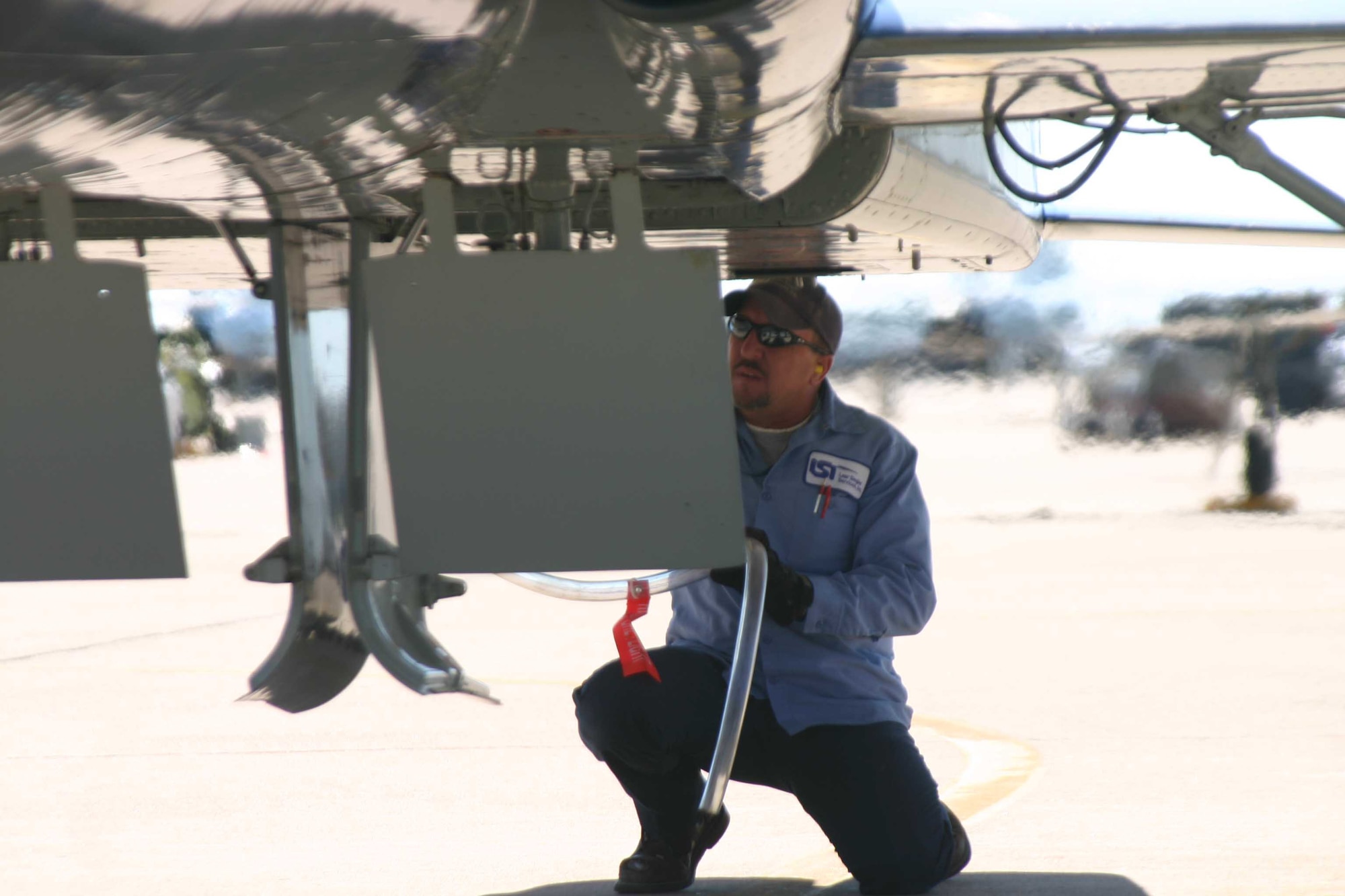 Lear Siegler, Inc., crew chief Rick Dixon connects a catch  hose to a T-38 Talon after the aircraft landed recently. Civilian contractors launch and recover all aircraft at the 80th Flying Training Wing. (U.S. Air Force photo/Robert Fox)