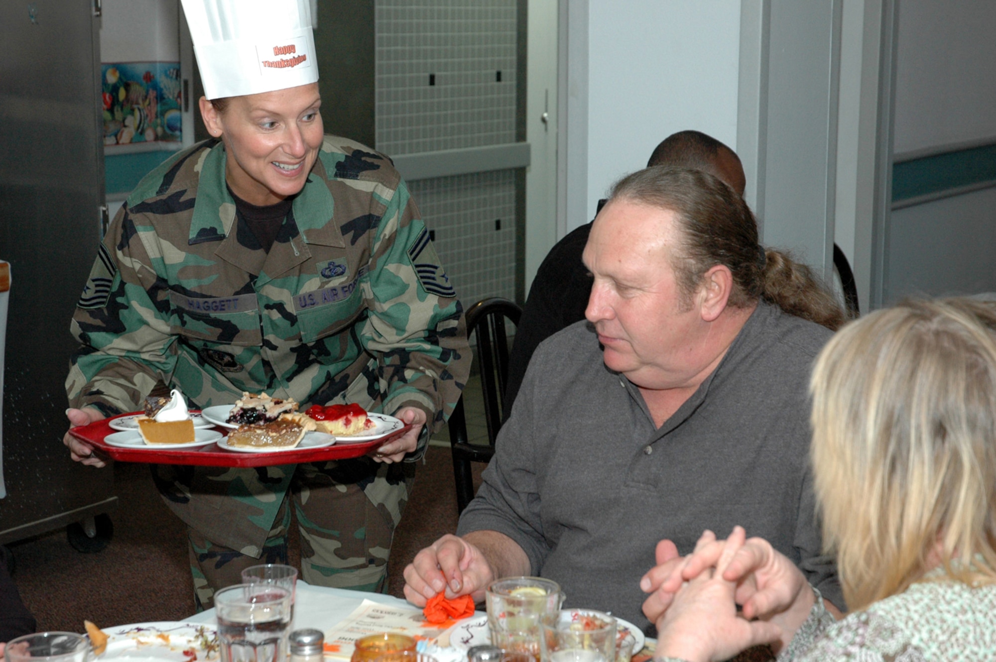 Senior Master Sgt. Lisa Haggett, Air Force Special Operations Command headquarters, offers retired Tech. Sgt. Terry Johnson dessert during the Thanksgiving meal in The Reef. Hurlburt Field commanders, chief master sergeants and first sergeants served diners food, drinks and rolls in the dining rooms. (U.S. Air Force Photograph by Master Sgt. Stuart Camp)