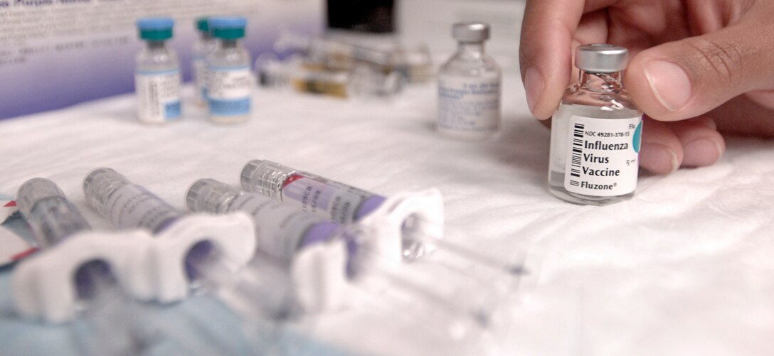 Immunization and Allergy Technition Senior Airman Sherrill Price of the 1st Medical Squadron  reaches for the frequently needed flu vaccination before giving a shot to Senior Airman Jessica Friedman on November 28, 2006.    U.S. Air Force photo by Airman 1st Class Vernon Young.