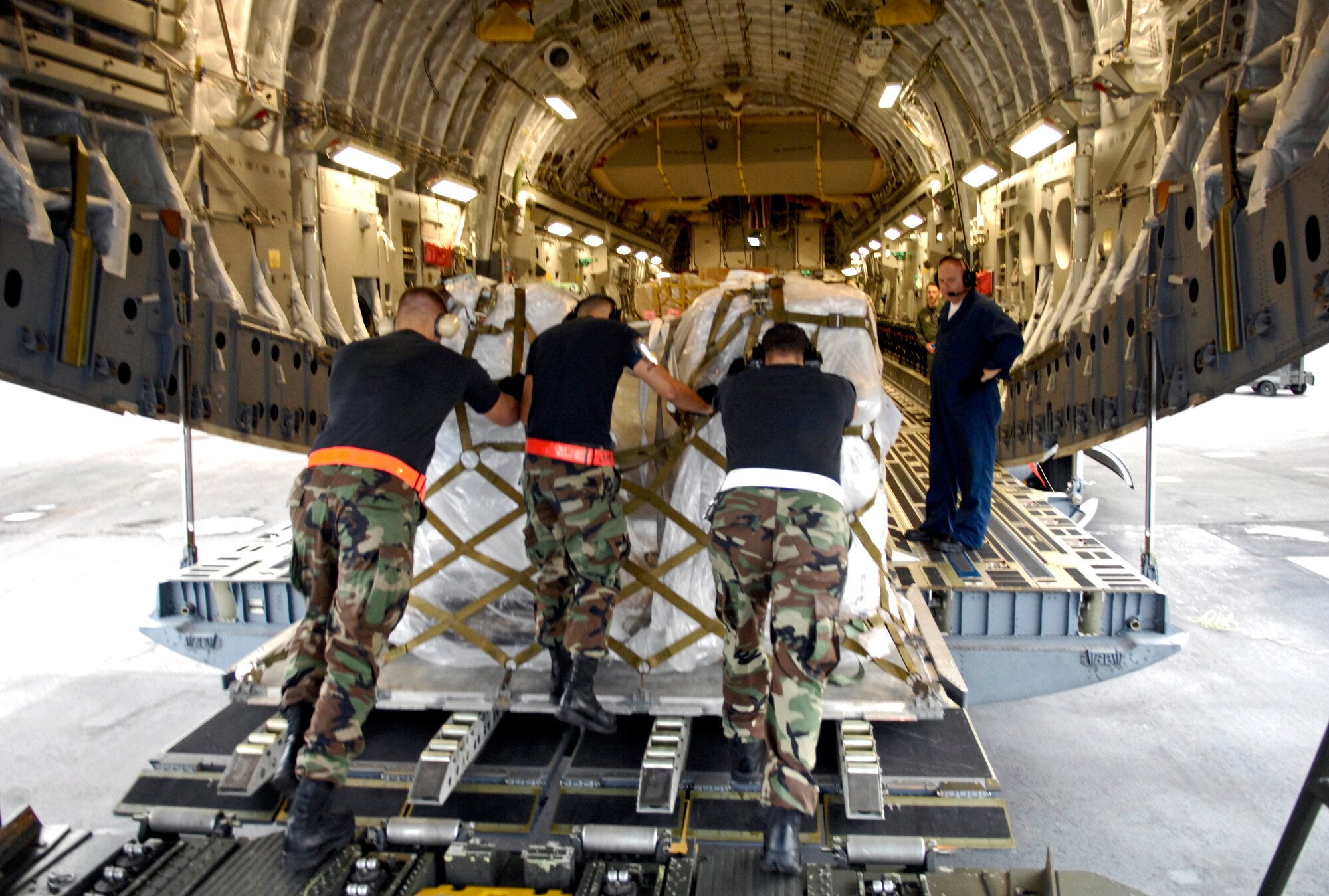 Members from the 735th Air Mobility Squadron load a pallet of two ultrasound units on a C-17 Globemaster III at Hickam Air Force Base, Hawaii, Nov. 29. The ultrasound units are being delivered to Thuy Duong Village, Vietnam. (U.S. Air Force photo/Tech. Sgt. Shane A. Cuomo)  
