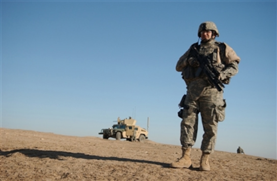U.S. Army Sgt. Alexis Madena, with 2nd Battalion, 124th Infantry Division, stands watch near an Iraqi police checkpoint in Tall Afar, Iraq, on Nov. 26, 2006. Madena's unit is responsible for training and evaluating local Iraqi police forces on day-to-day operations.  